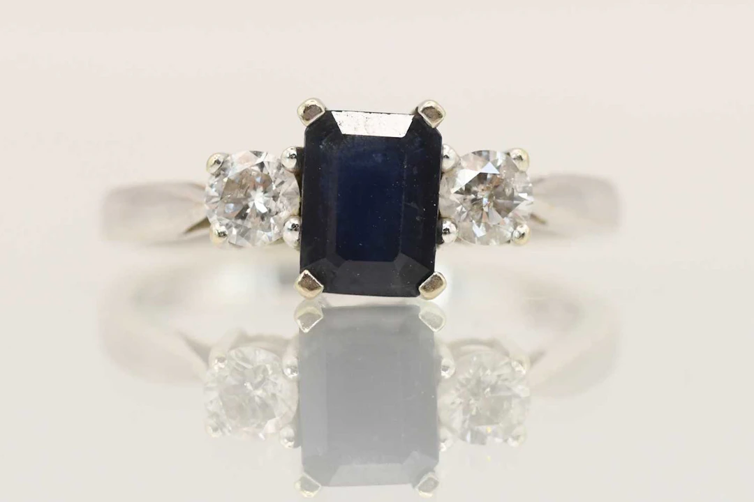 An 18ct white gold sapphire and diamond set three stone ring