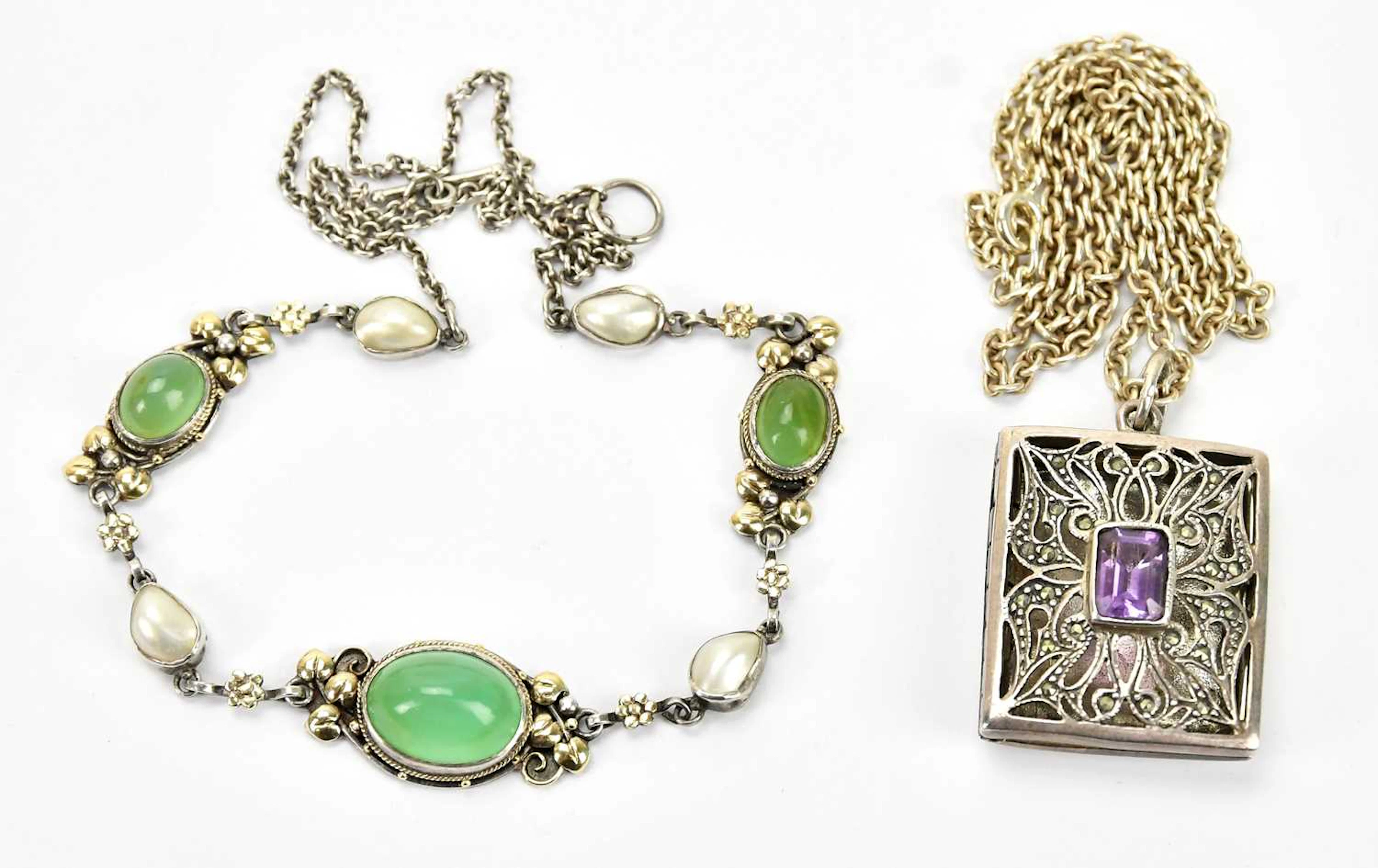 A sterling silver locket with central amethyst coloured stone