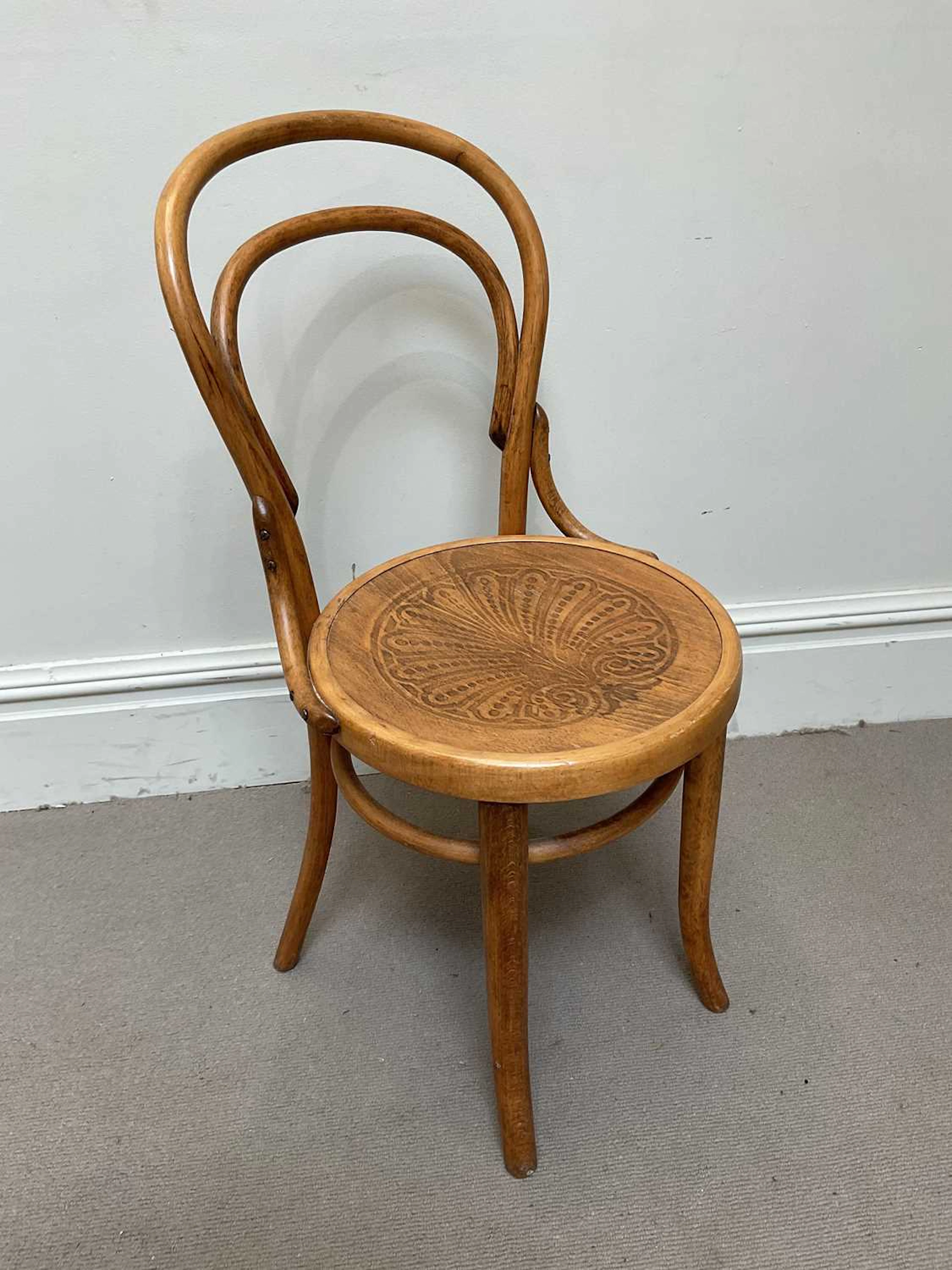 A vintage Thonet style bentwood cafe chair with pokerwork seat