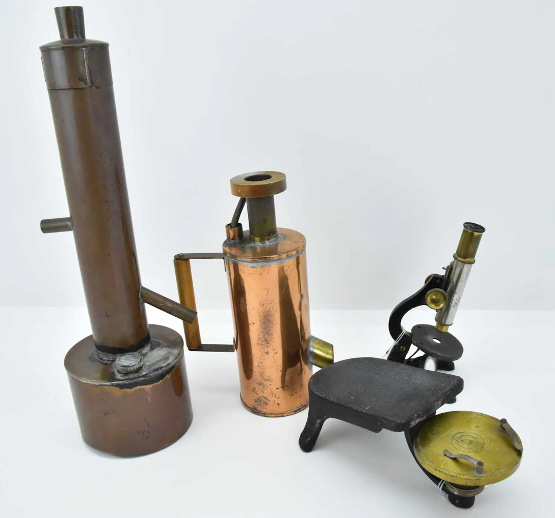 Four items of vintage scientific equipment comprising a student microscope