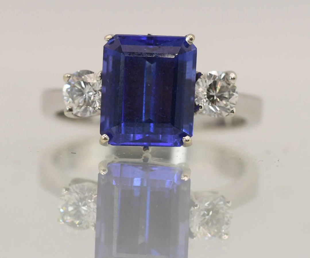 An 18ct white gold blue tanzanite and diamond three stone ring