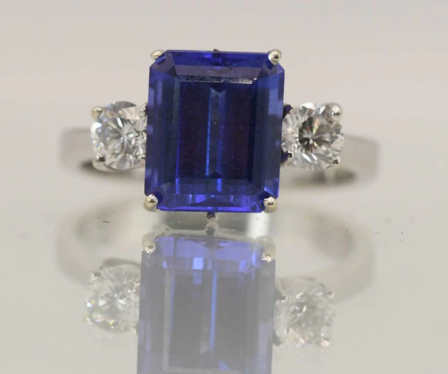 An 18ct white gold blue tanzanite and diamond three stone ring
