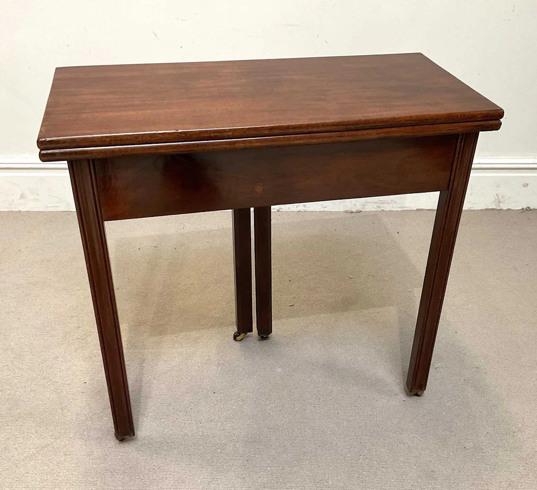 A George III mahogany tea table with rectangular foldover...