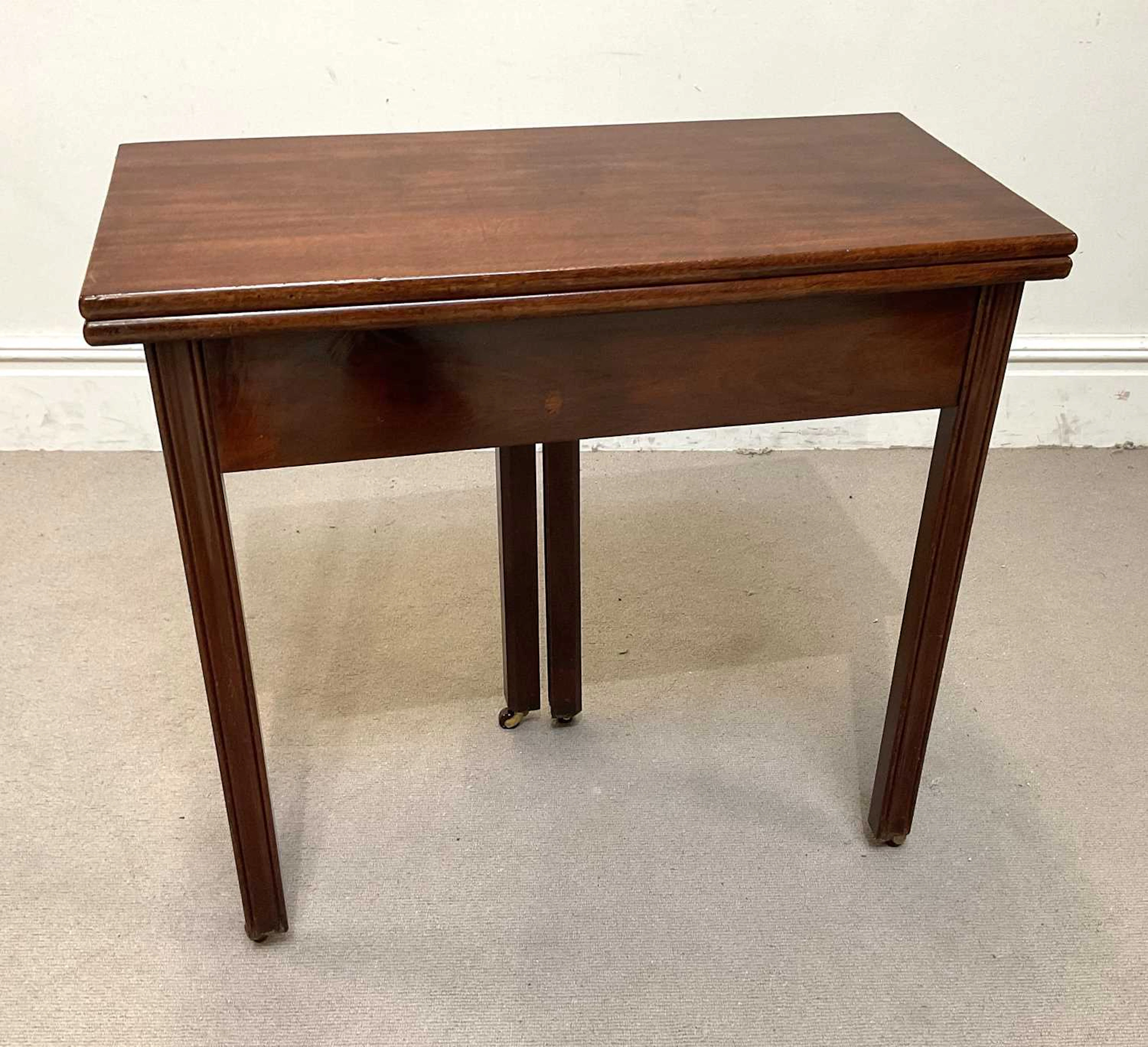 A George III mahogany tea table with rectangular foldover...
