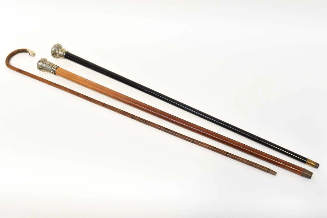 Three silver-topped walking sticks comprising an ebony stick