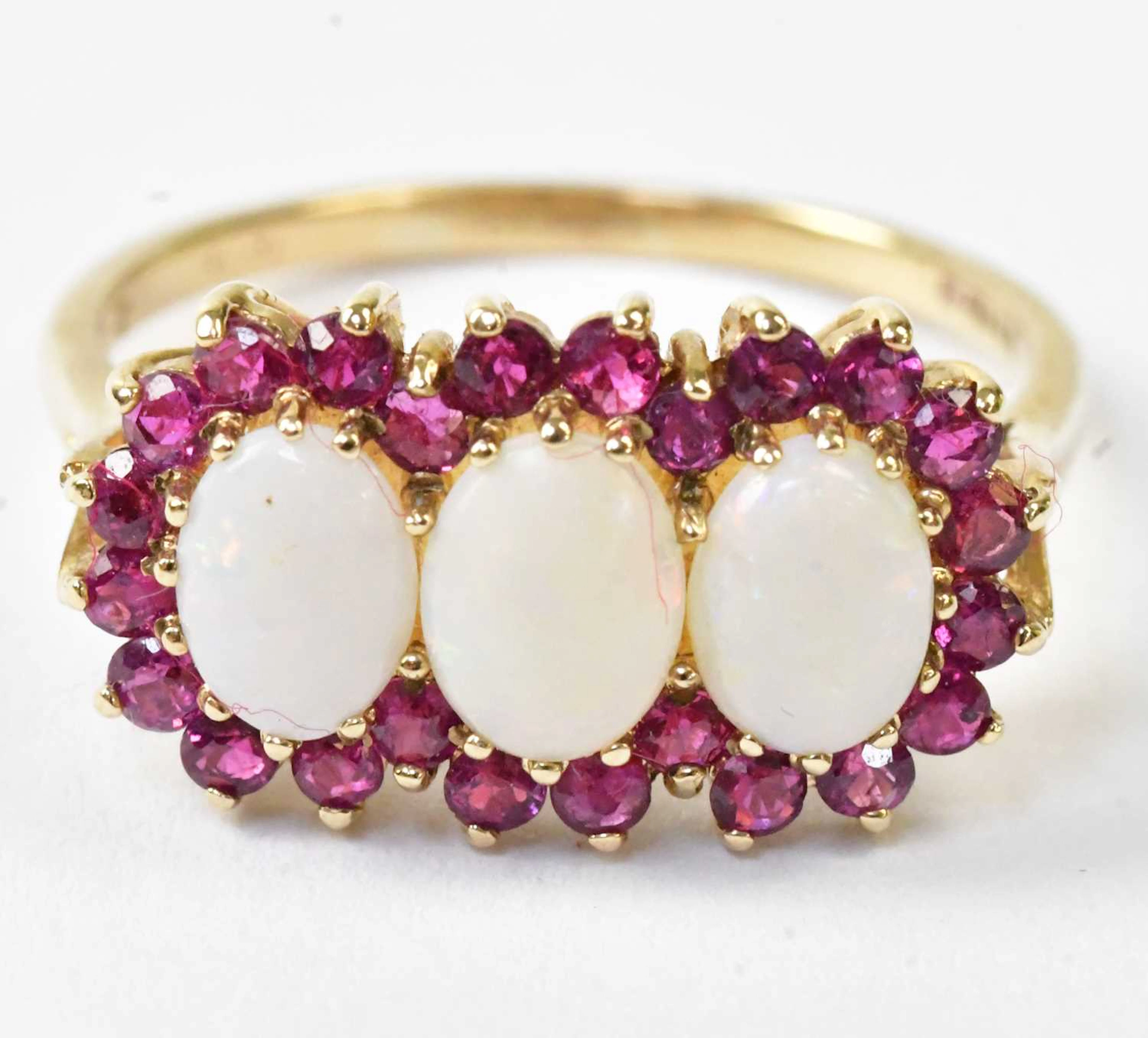 A 9ct yellow gold ring set with three oval opal cabochons...