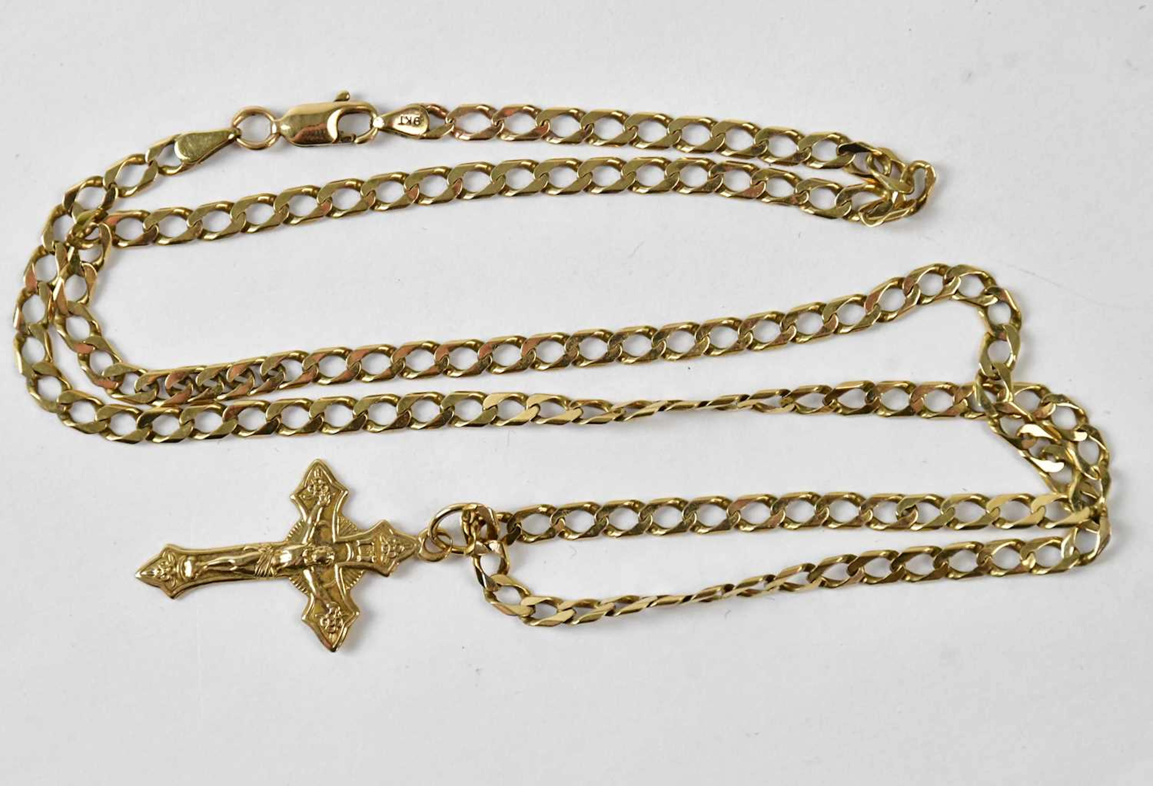 A yellow metal crucifix pendant