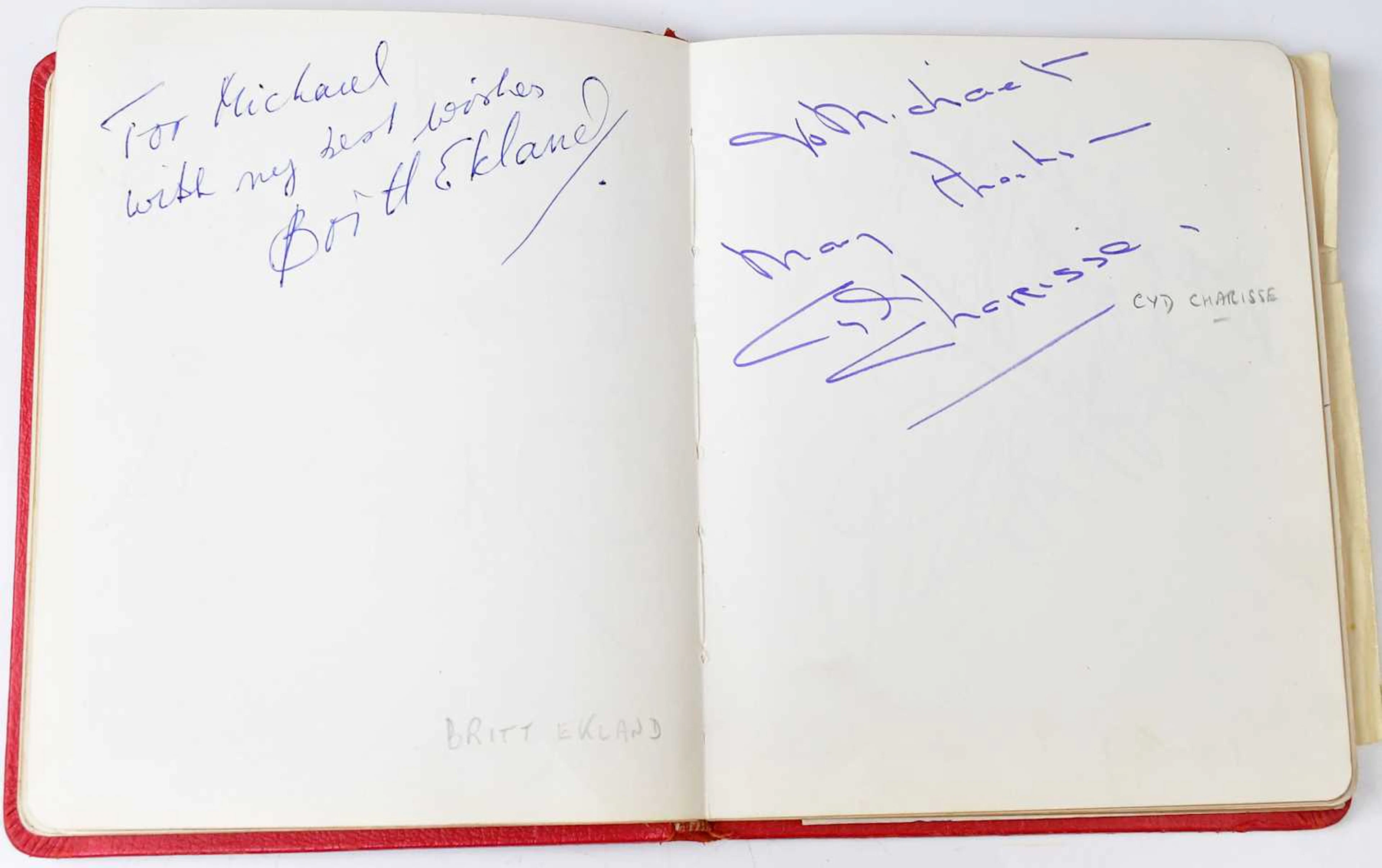 A vintage red autograph book containing a large quantity of autographs