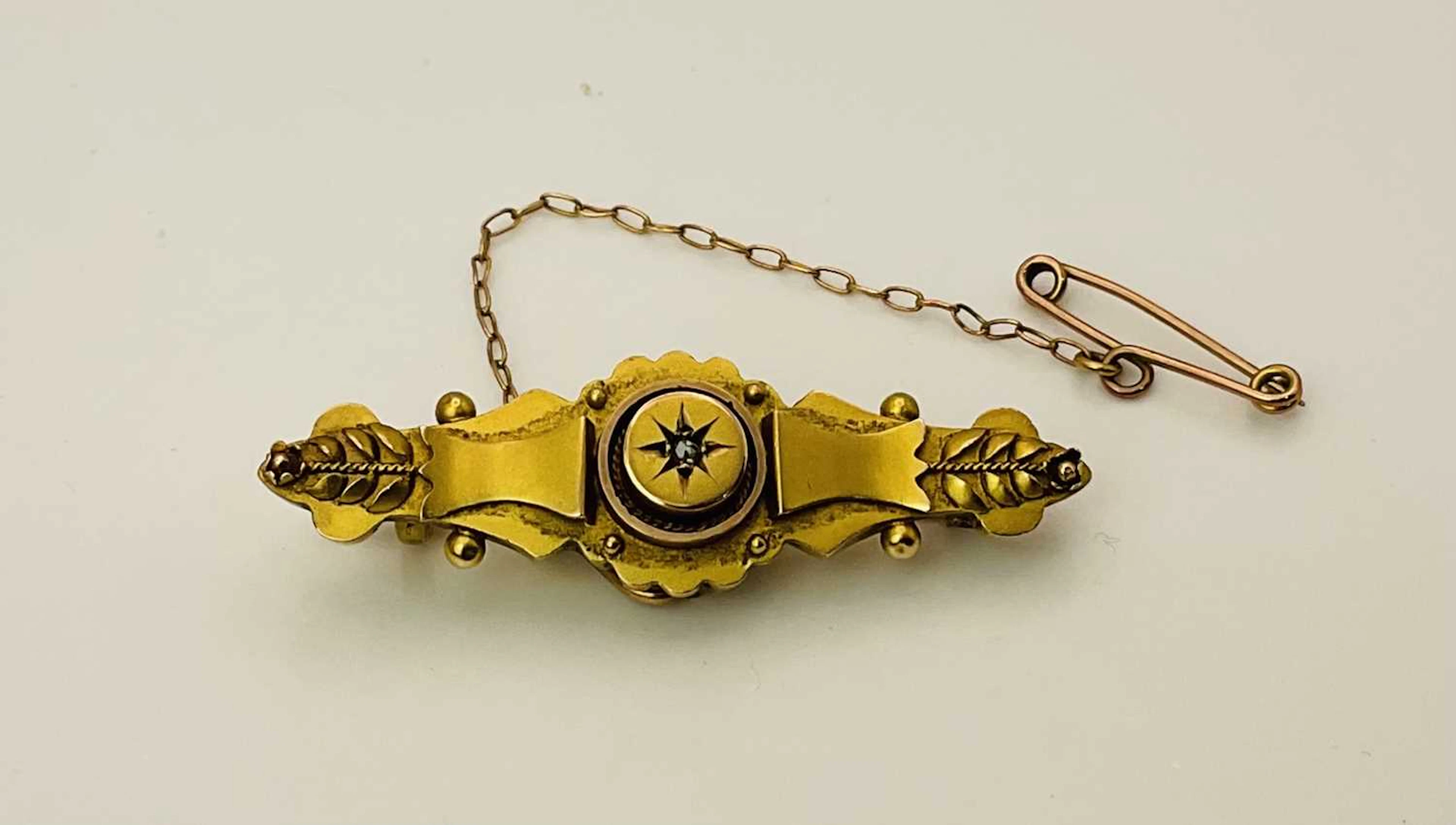 A hallmarked 375 gold brooch with safety chain
