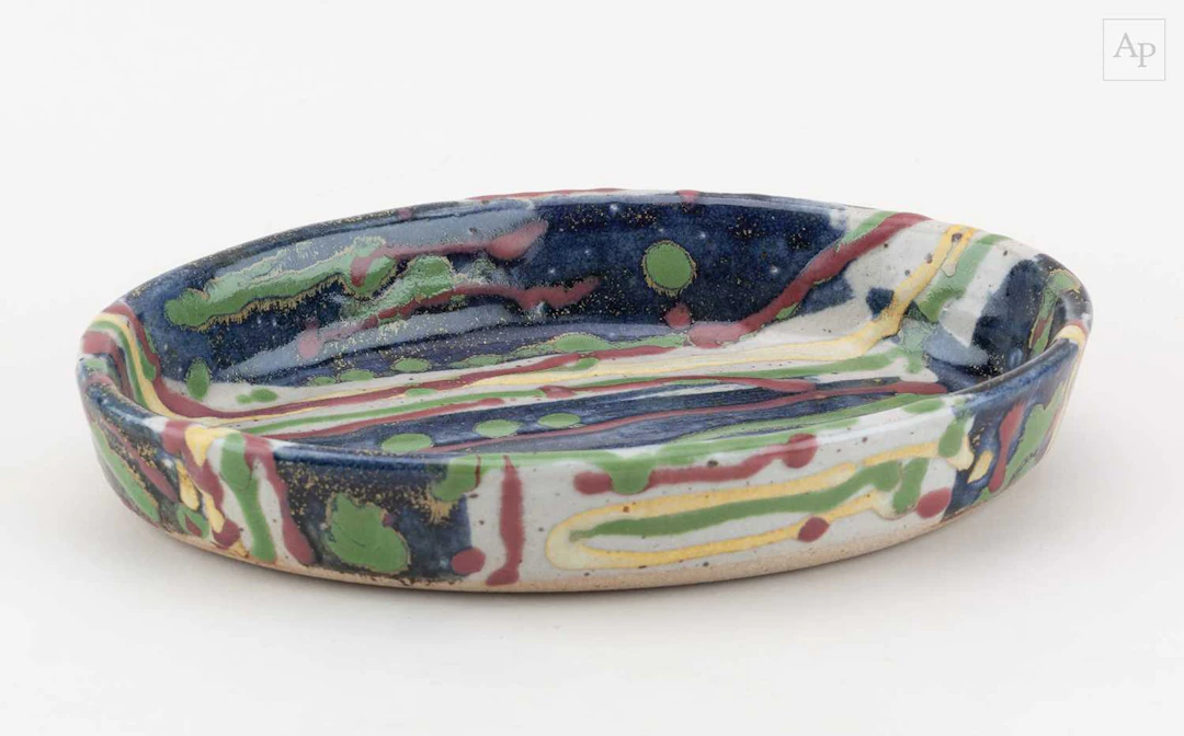 JANICE TCHALENKO (1942-2018); an oval stoneware dish covered in polychrome glaze