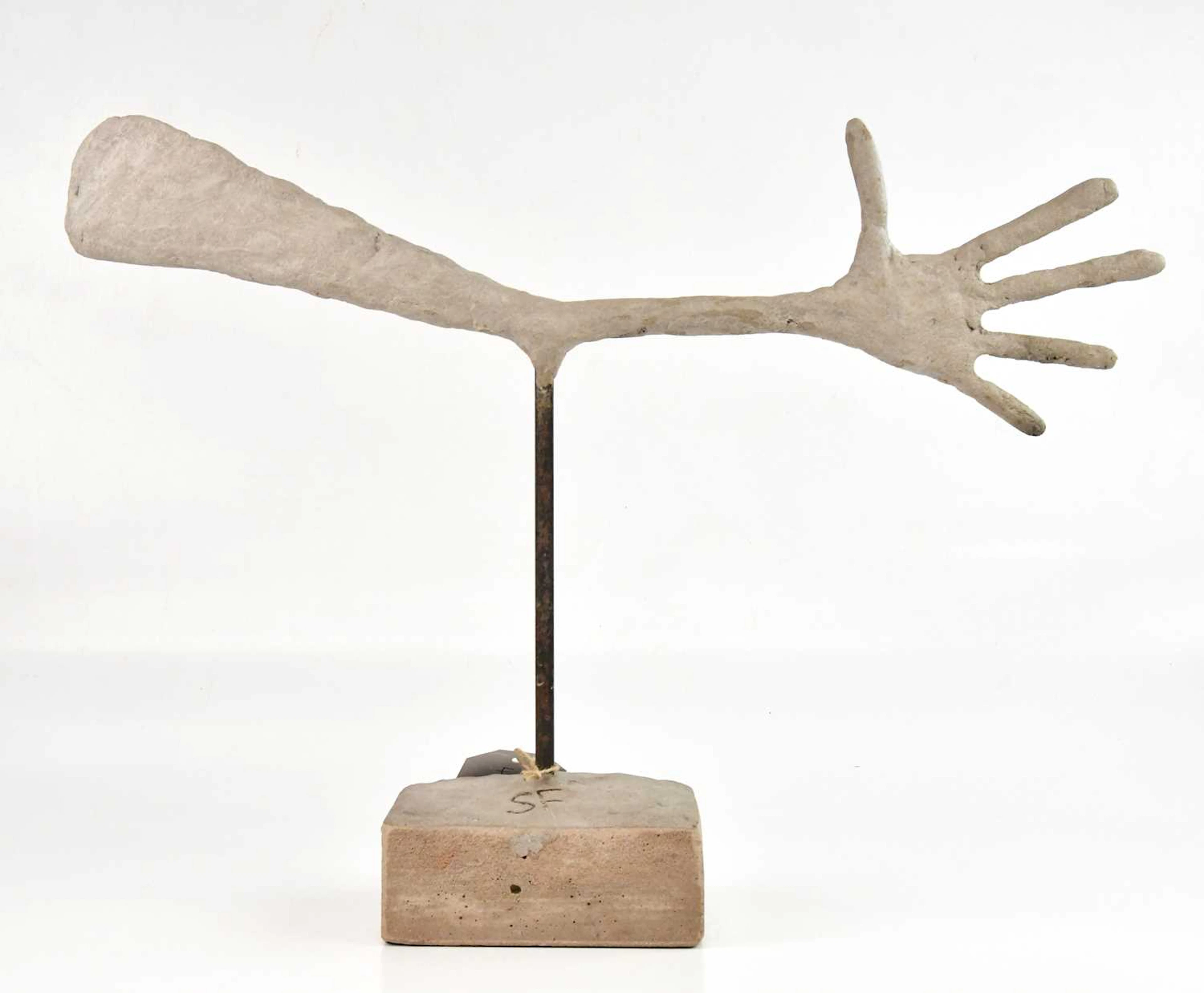An Alberto Giacometti style concrete sculpture of an extended arm