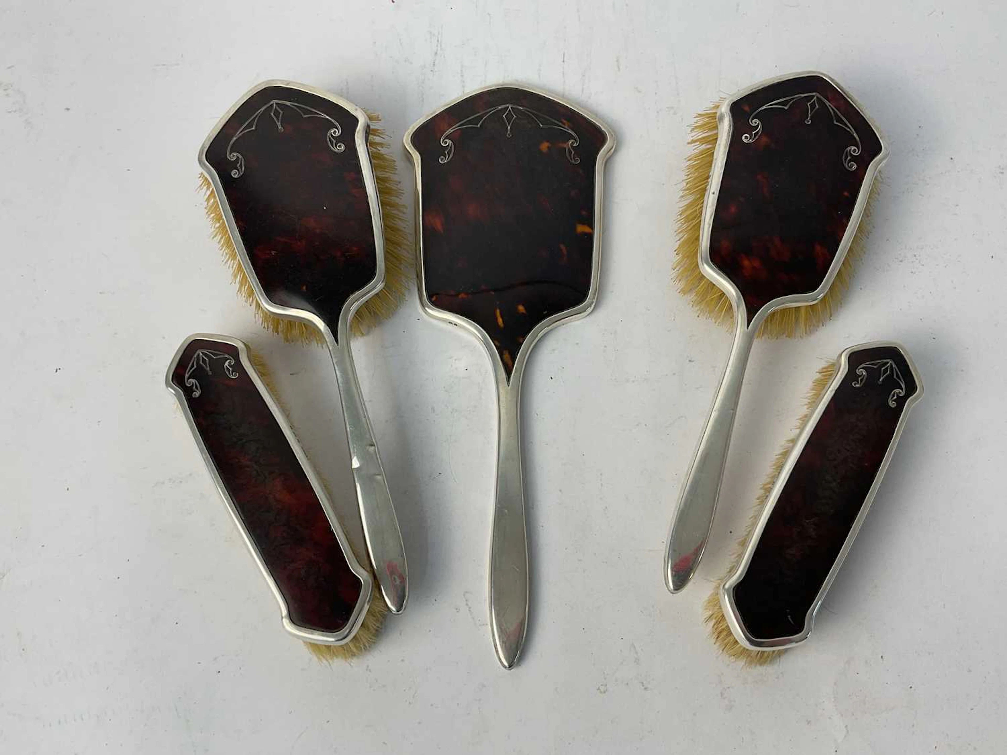 A George V five piece hallmarked silver tortoiseshell effect dressing table set