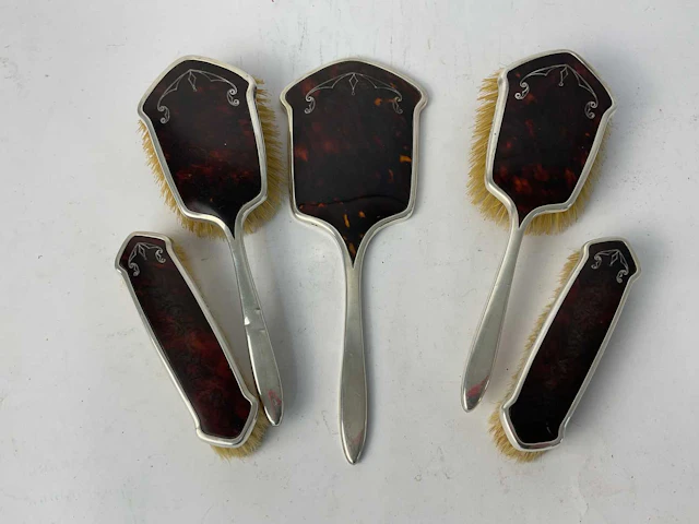 A George V five piece hallmarked silver tortoiseshell effect dressing table set