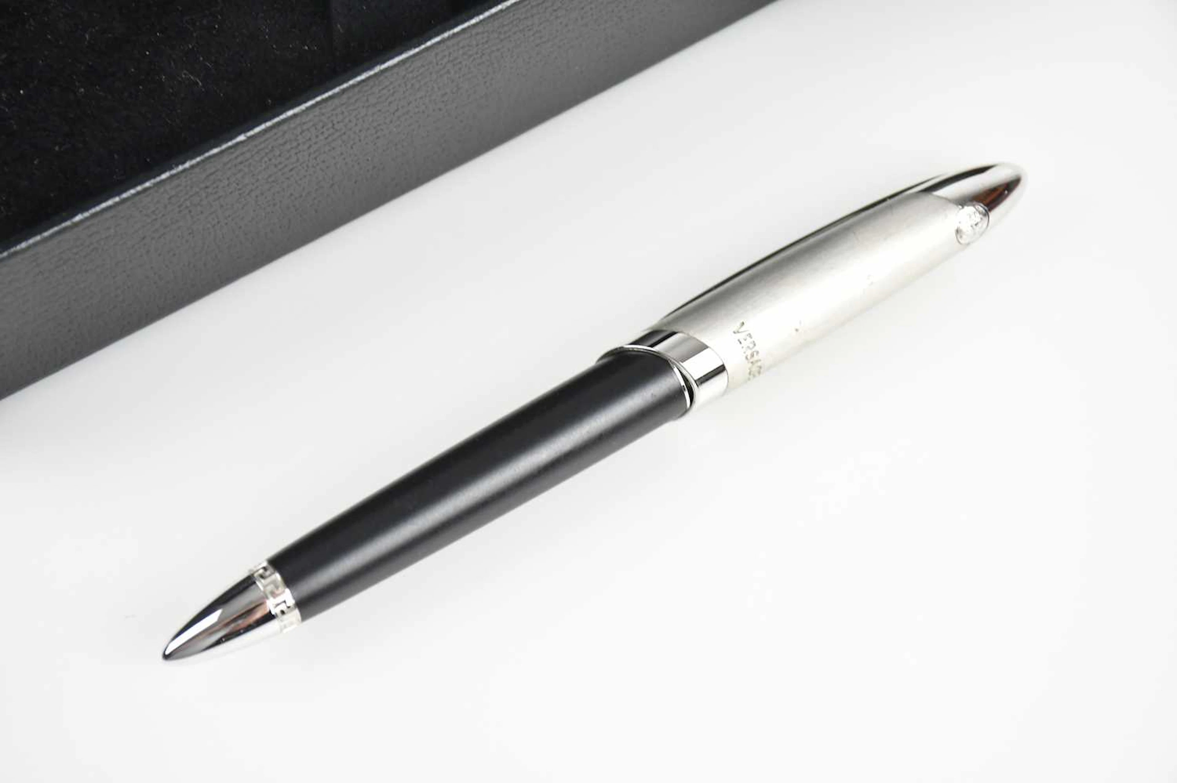 GIANNI VERSACE; a black and chrome ballpoint pen