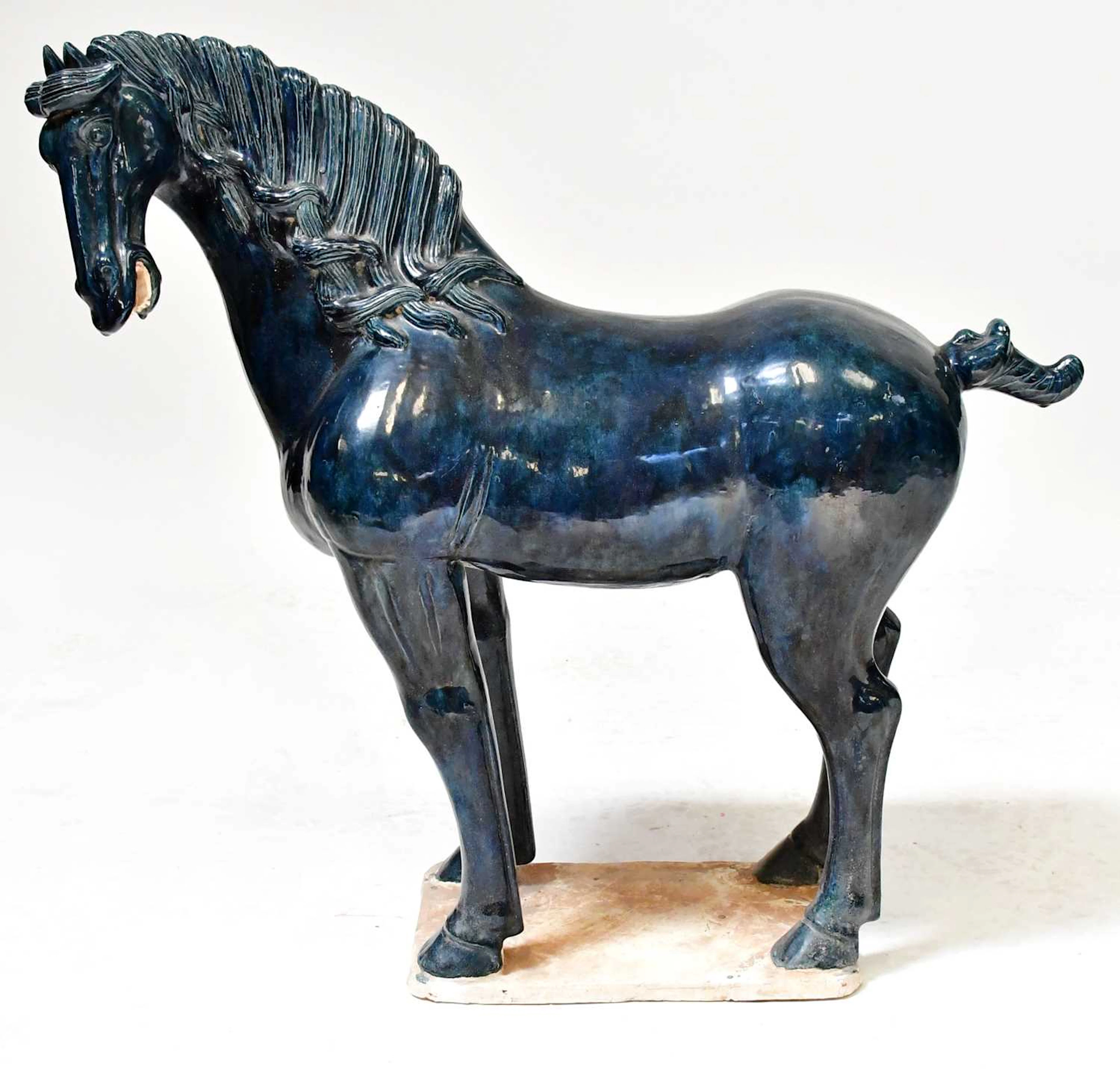 A Tang-style ceramic model of a standing horse in a blue glaze