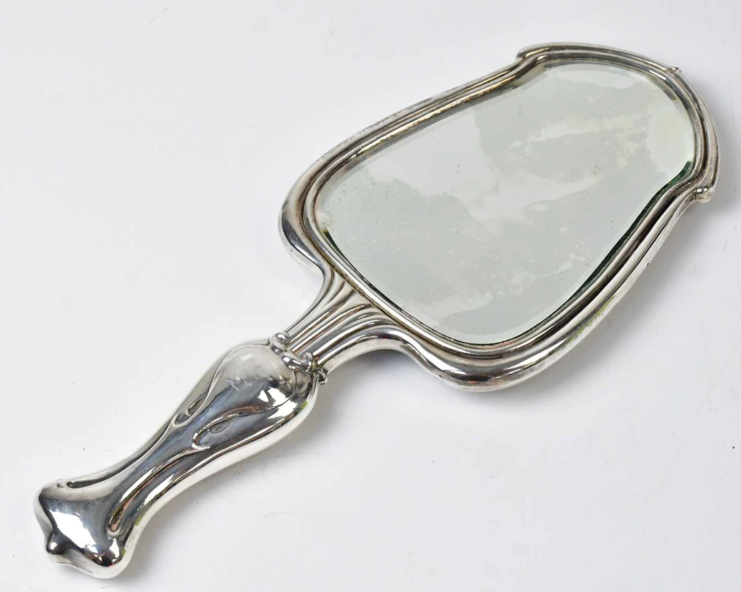 WILLIAM NEALE & SONS; an Edward VII hallmarked silver Art Nouveau hand mirror