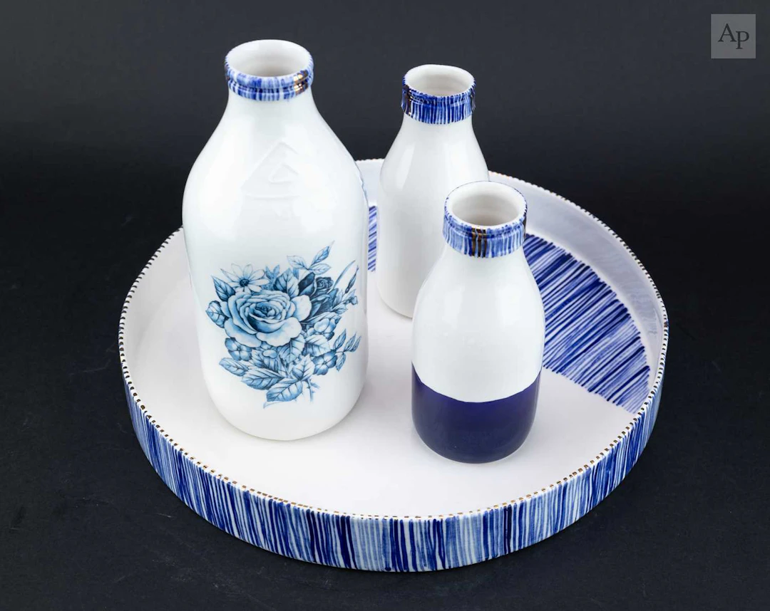 REBECCA KILLEN; a trio of bone china bottles decorated...