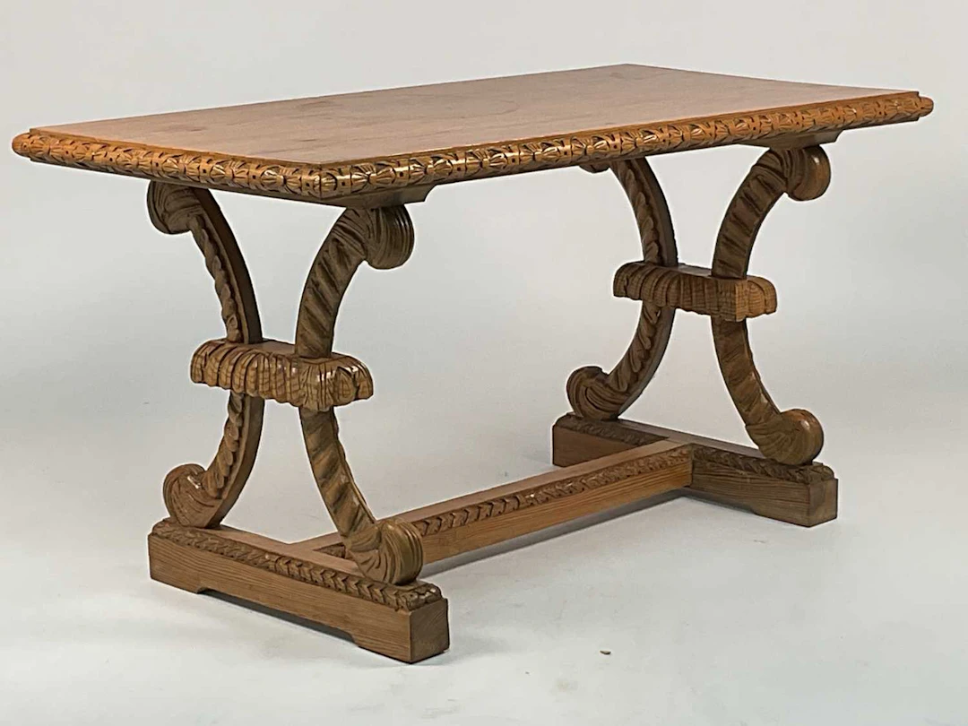 A carved pine side table with scrolled shaped double pedestal end supports