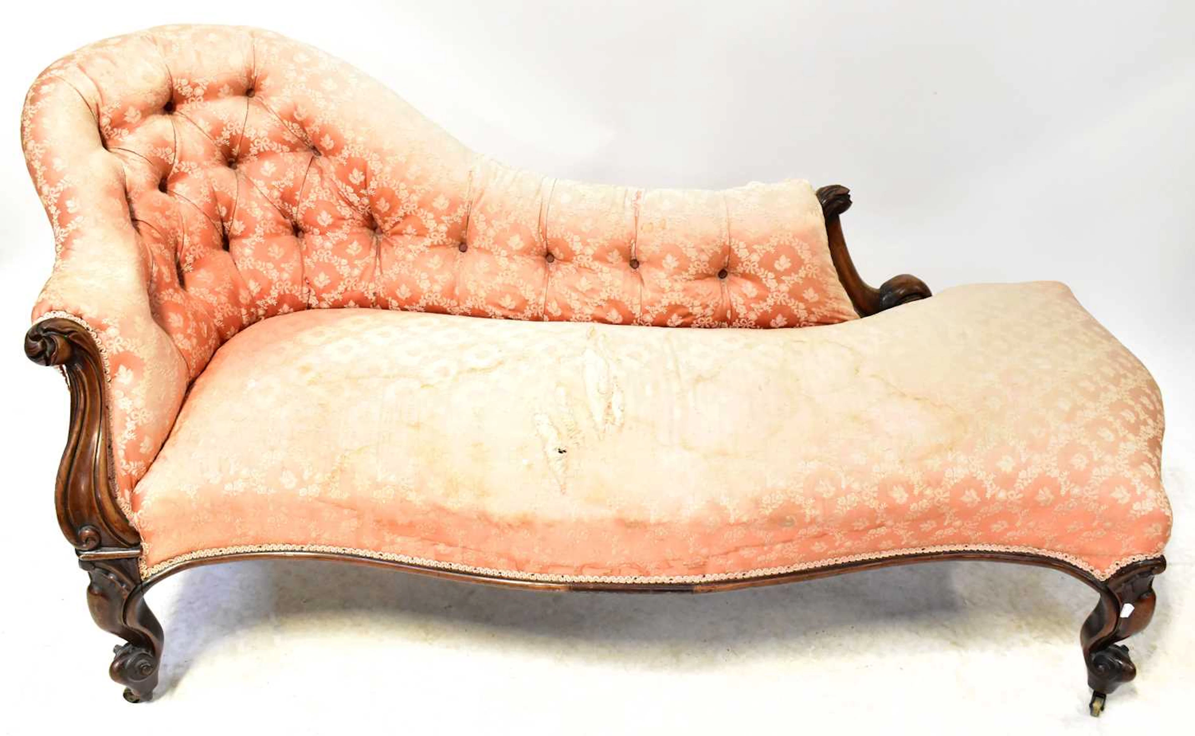 A Victorian walnut chaise longue with pink satin button-back upholstery