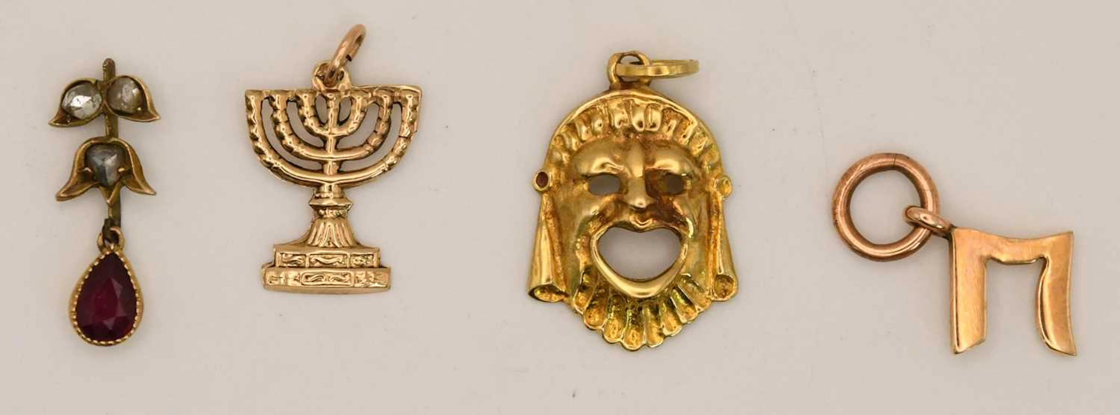 A 14K yellow gold bracelet charm modelled as a menorah candlestick