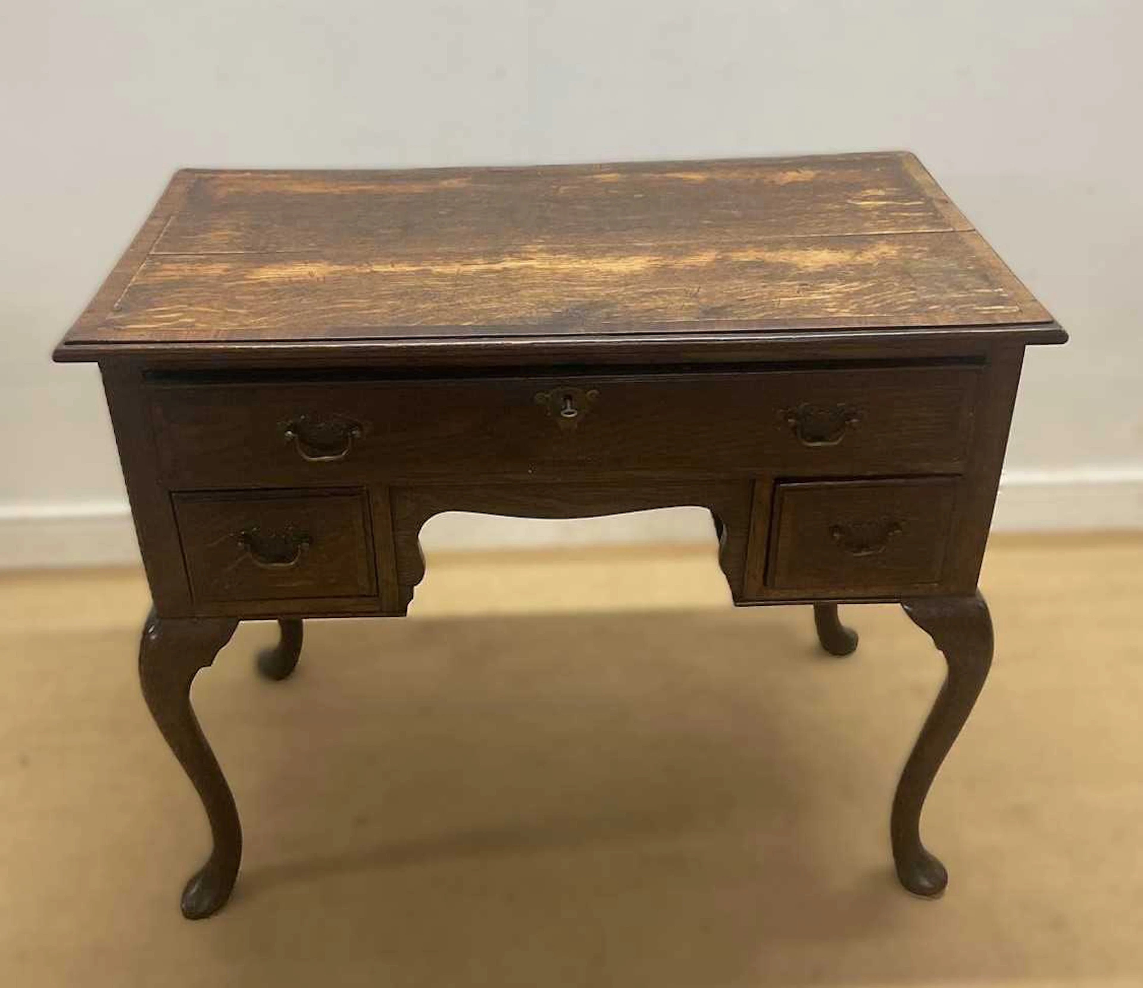 An oak veneer knee hole writing desk