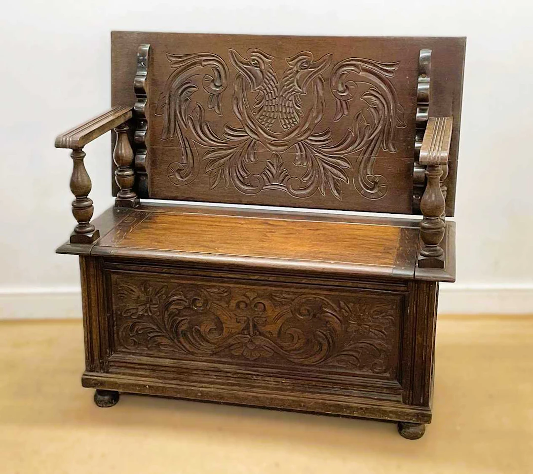 A 19th century carved oak monk's bench with storage beneath the seat