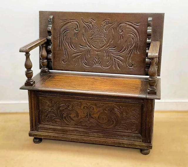 A 19th century carved oak monk's bench with storage beneath the seat