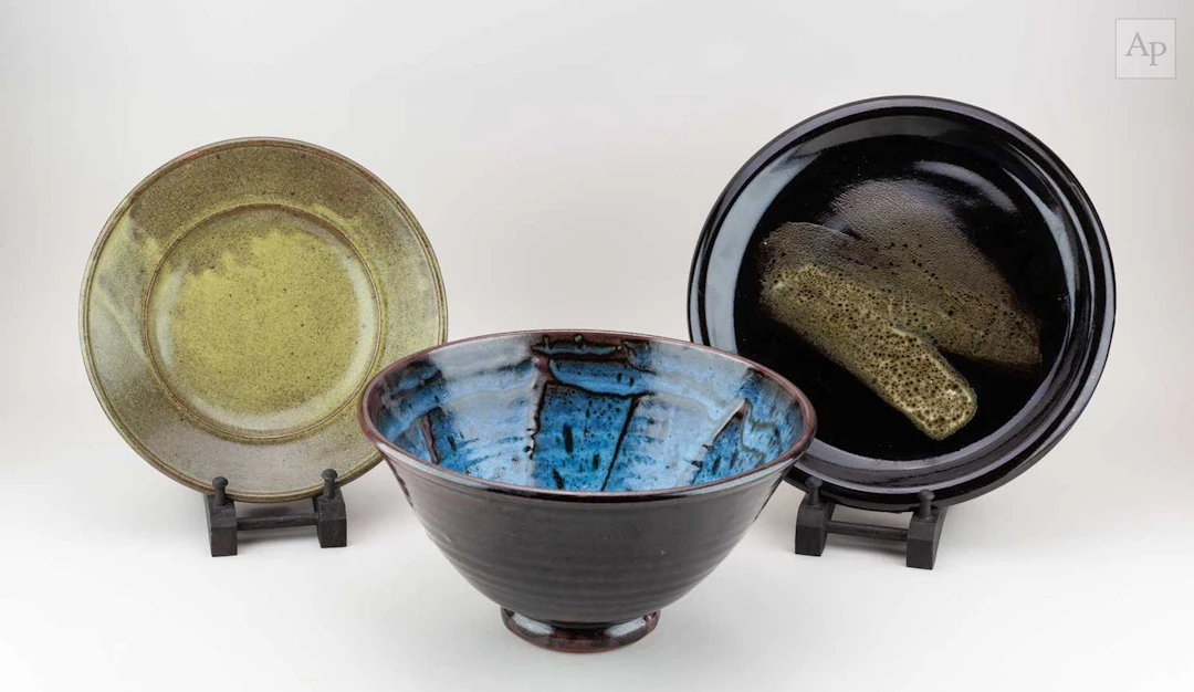 TIM ANDREWS (born 1960); a stoneware plate covered in mottled lime green glaze