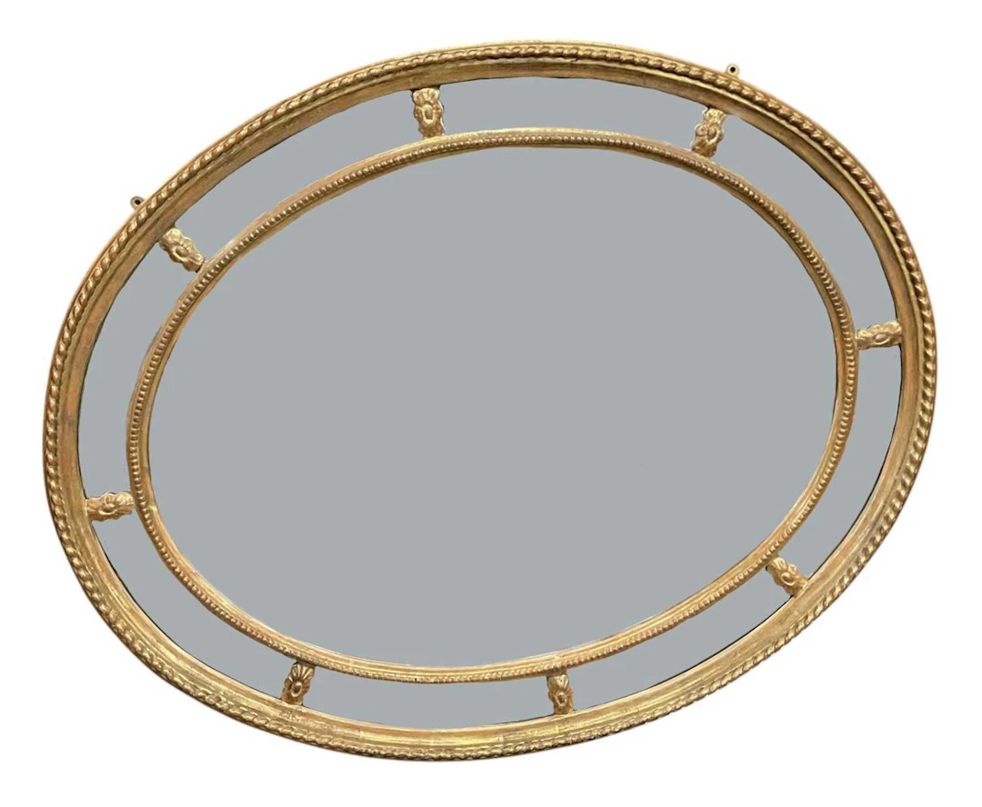 A modern oval gilt framed bevelled glass wall mirror