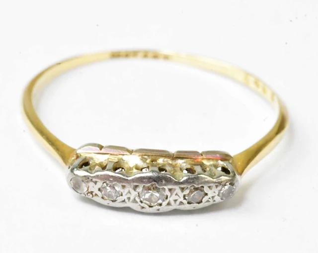 An 18ct yellow gold and platinum ring set with four diamonds (af