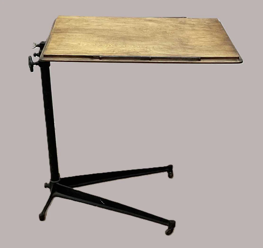 An adjustable oak reading over bed table with cast iron base