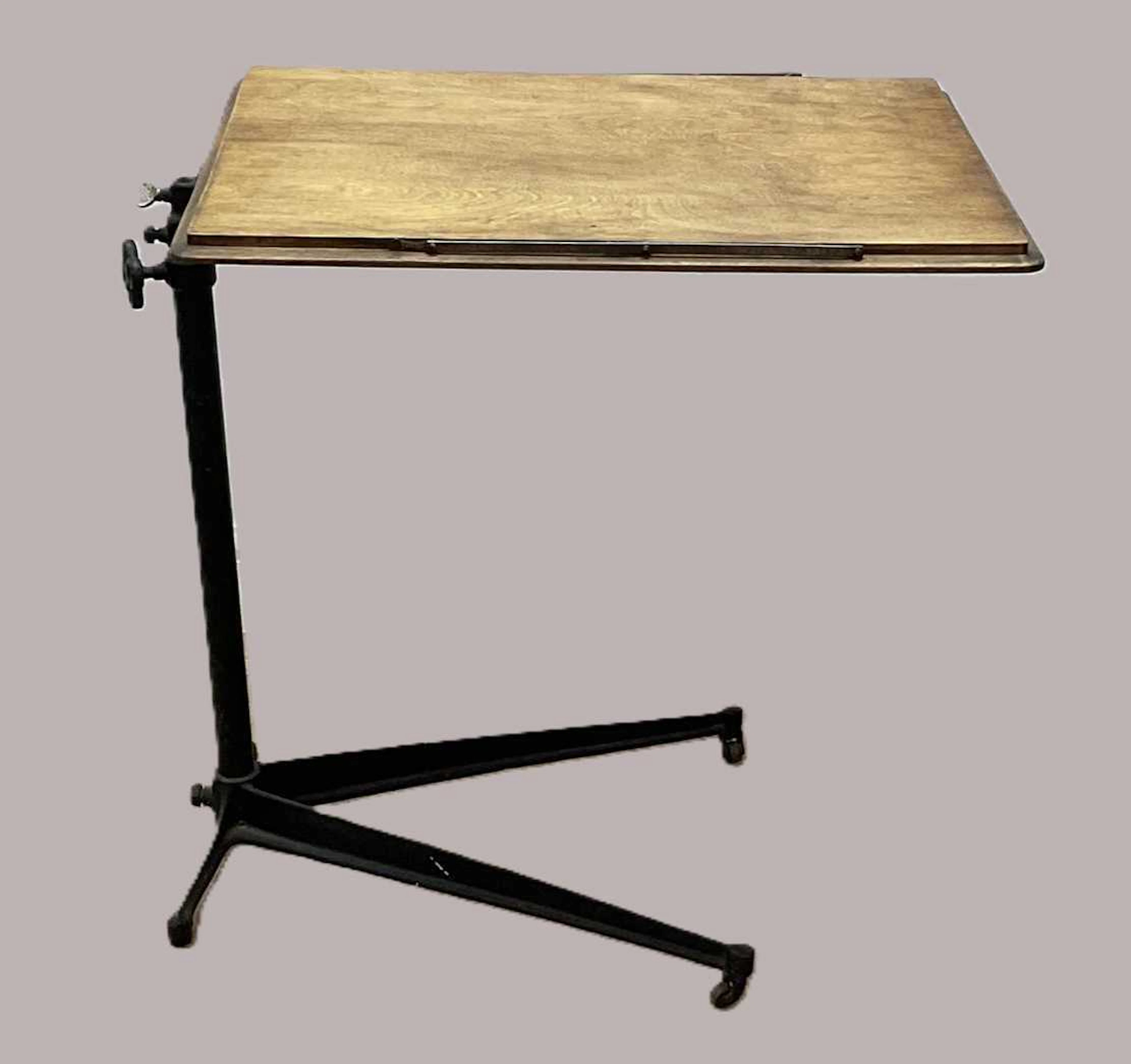 An adjustable oak reading over bed table with cast iron base