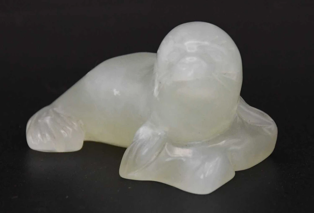 A small Chinese carved celadon jade figure of a seal