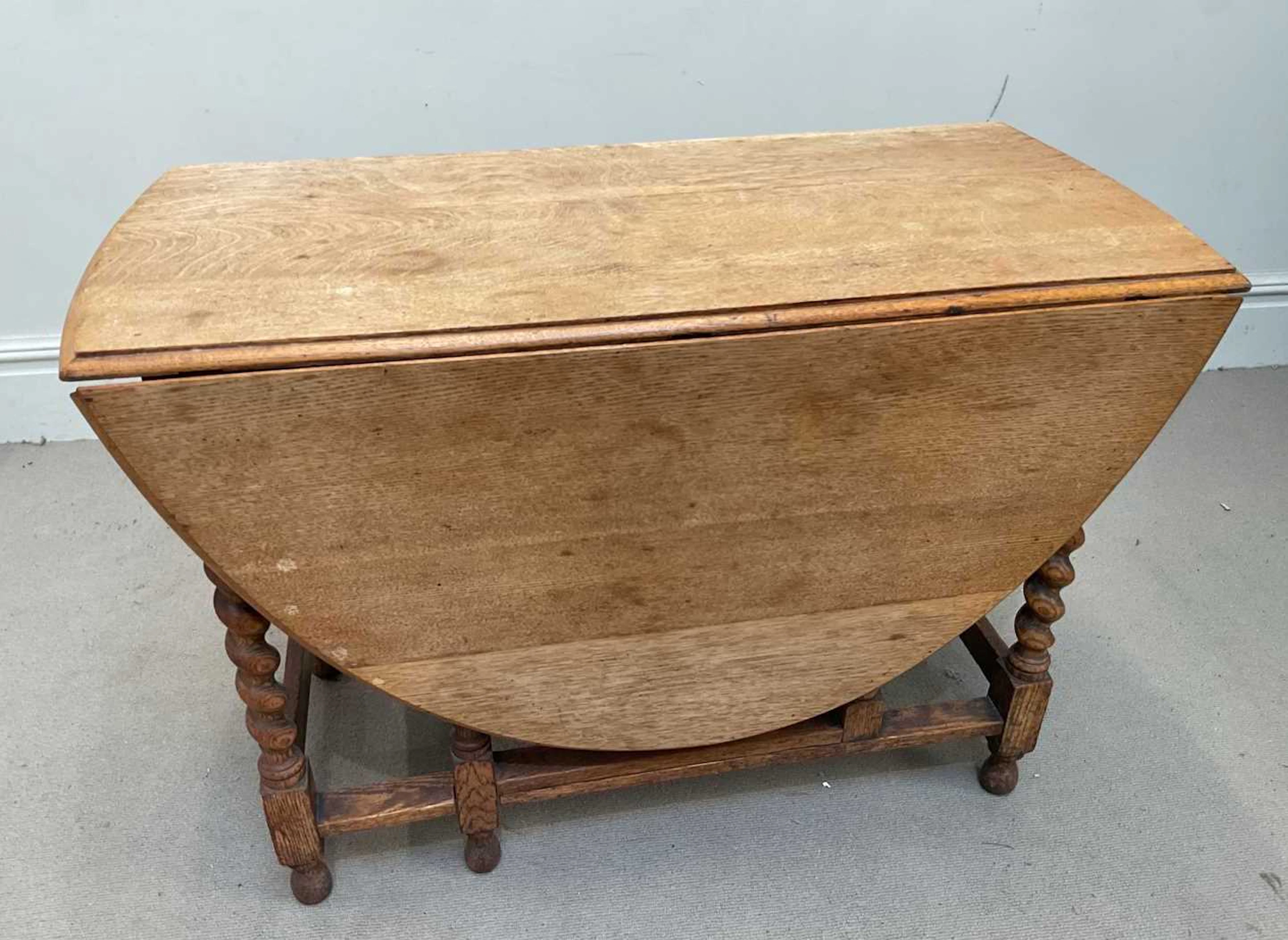 A 1920s oak drop-leaf dining table