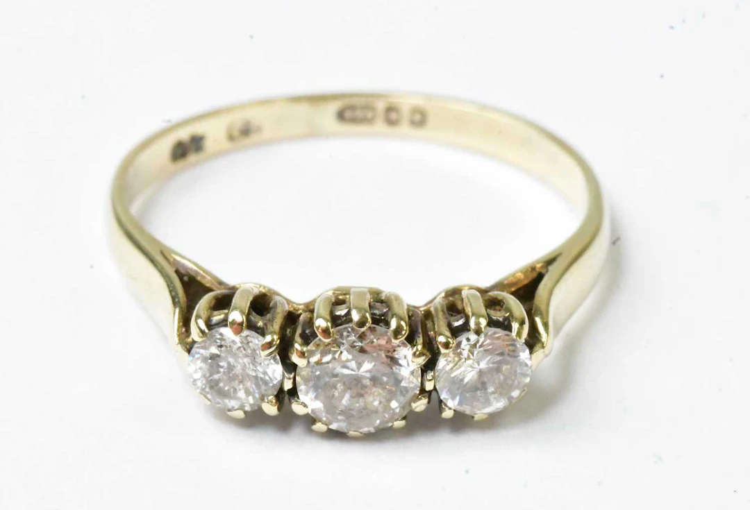 A 9ct yellow gold ring set with three white stones