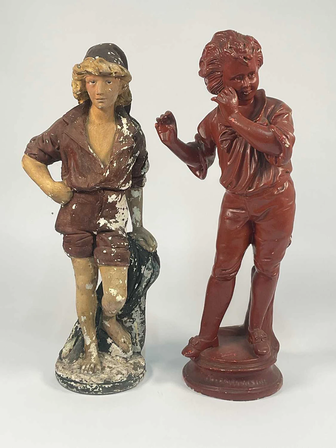 A large painted chalk ware figure of a boy in a cap