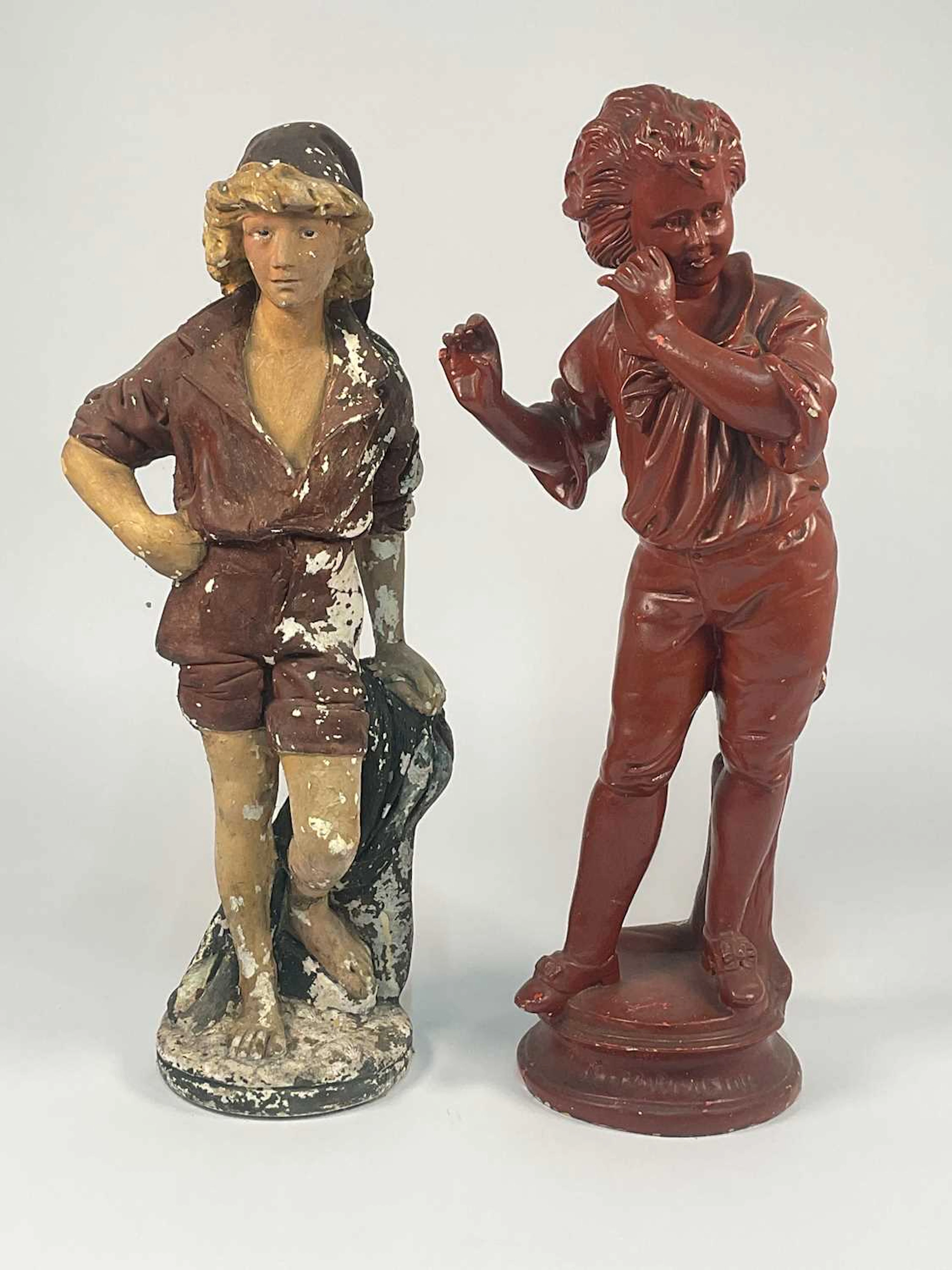 A large painted chalk ware figure of a boy in a cap