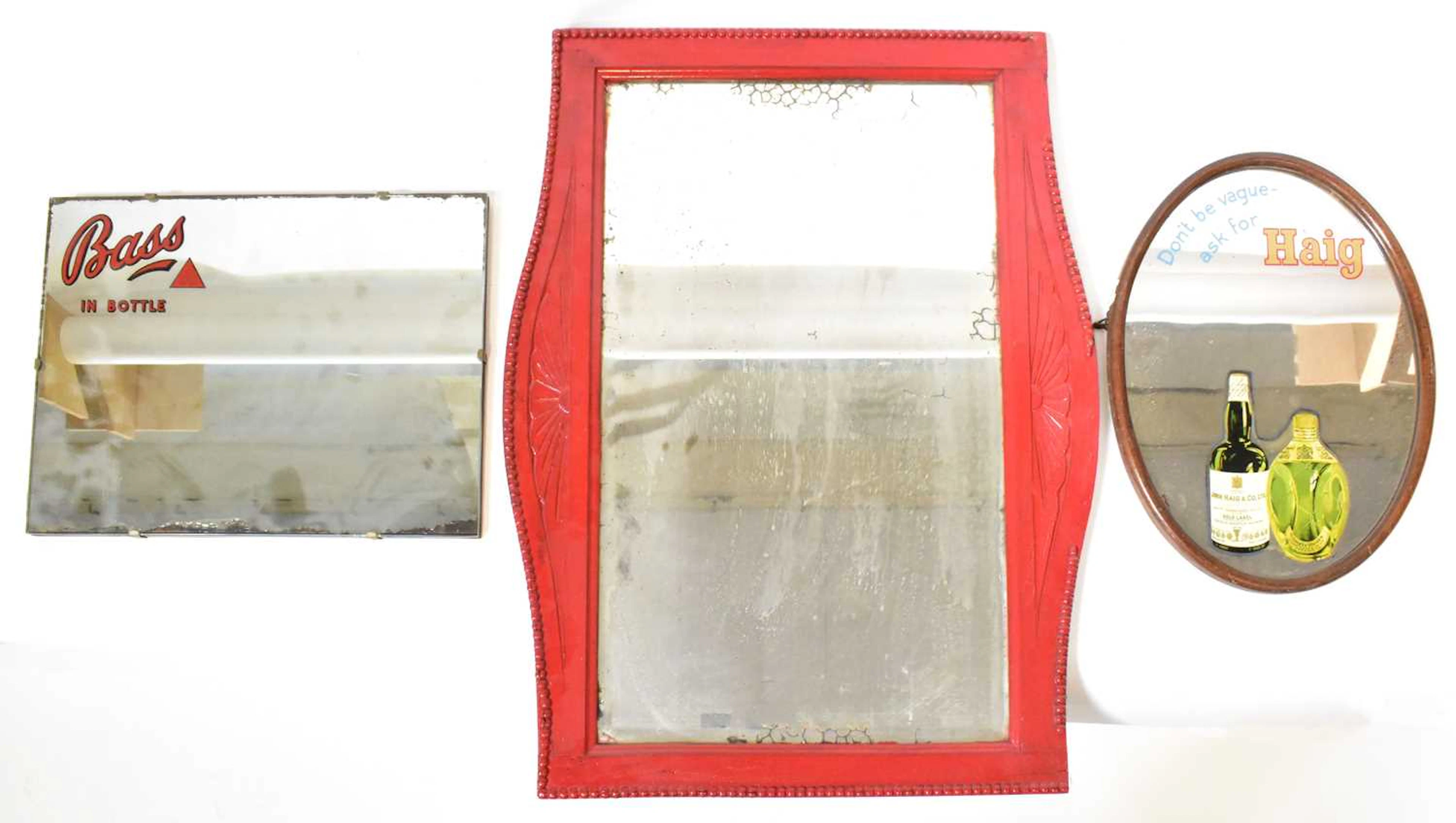A Haig whisky advertising mirror of oval form painted...