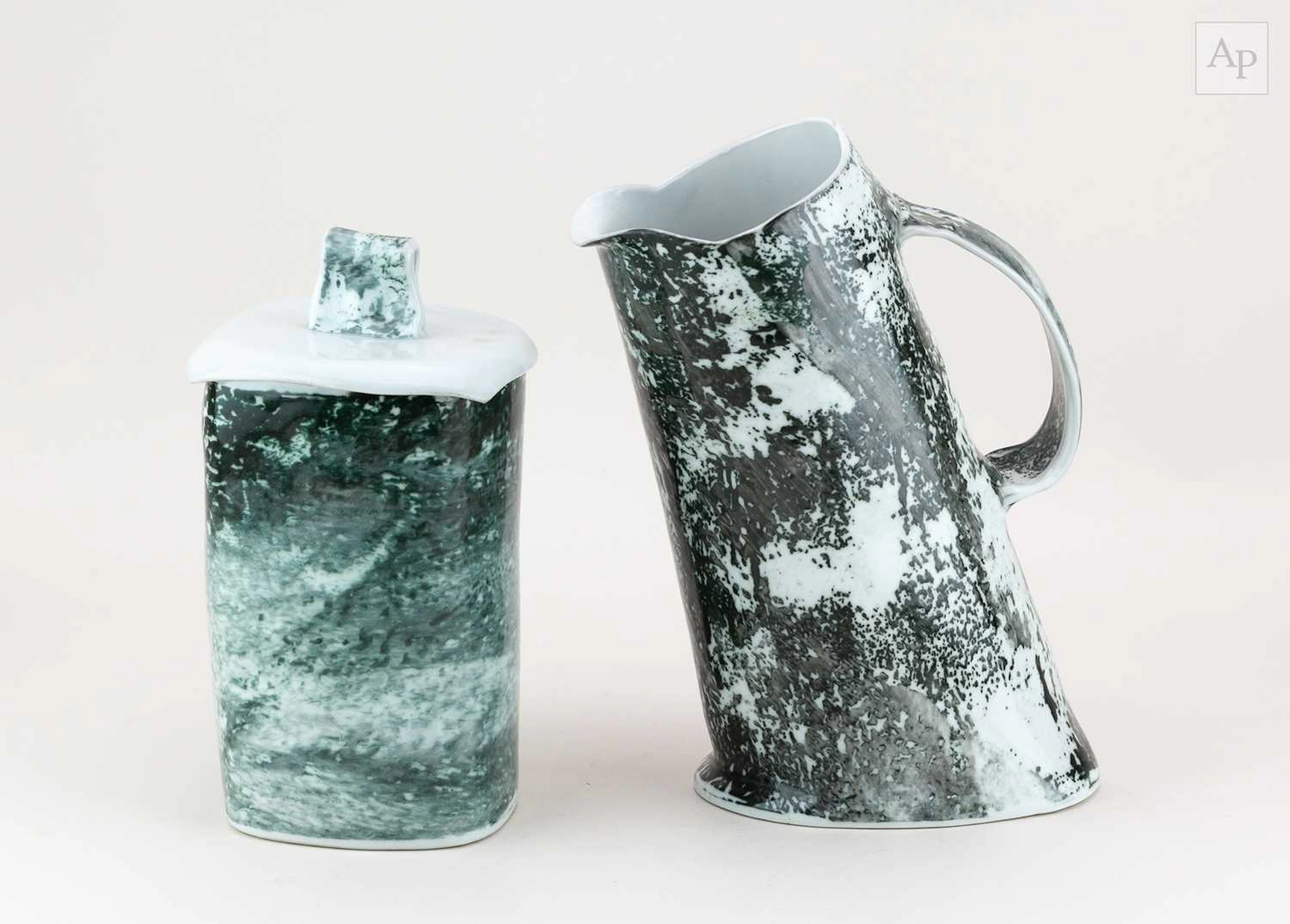 A leaning porcelain jug covered in carbon trap shino glaze