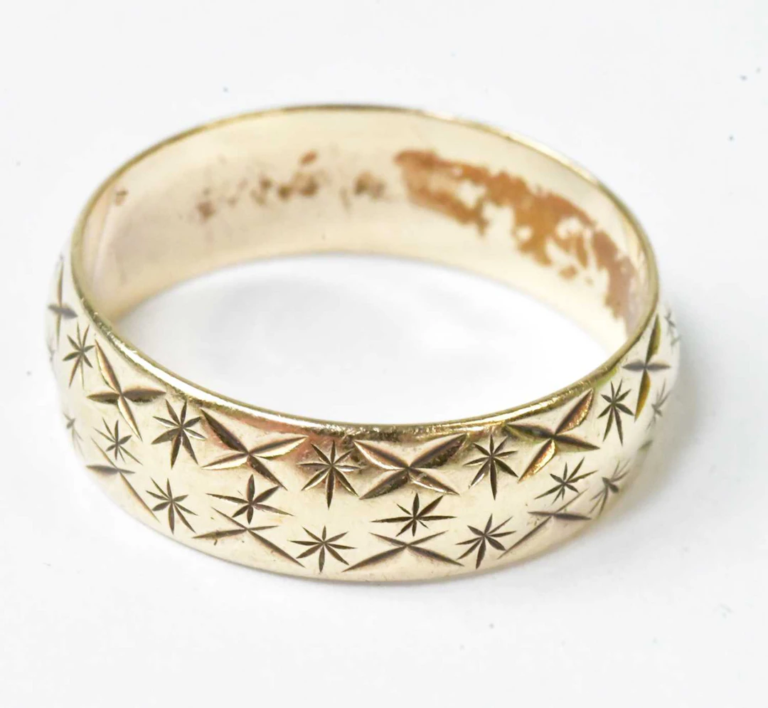 A 9ct yellow gold wedding band with engraved decoration