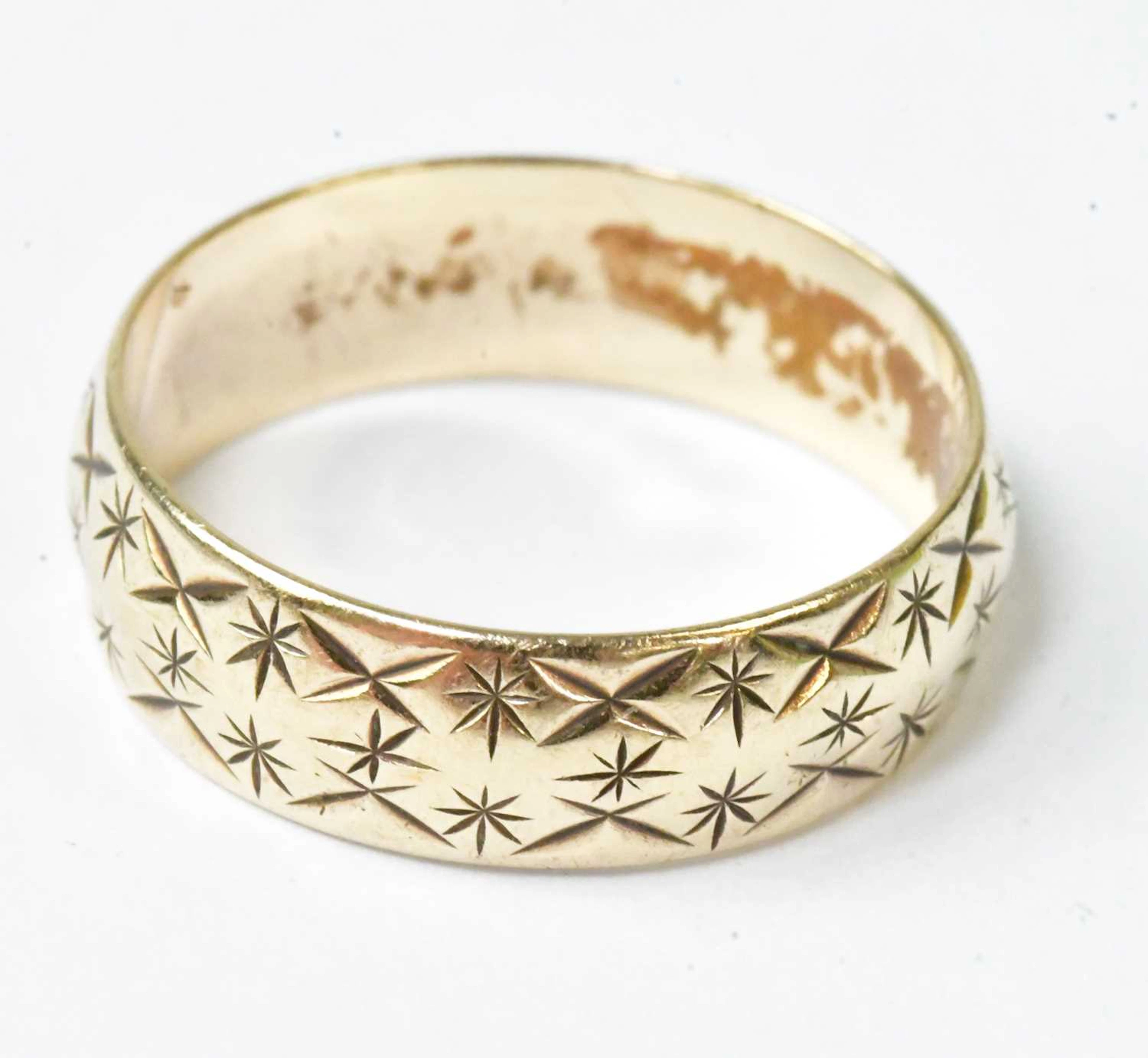 A 9ct yellow gold wedding band with engraved decoration