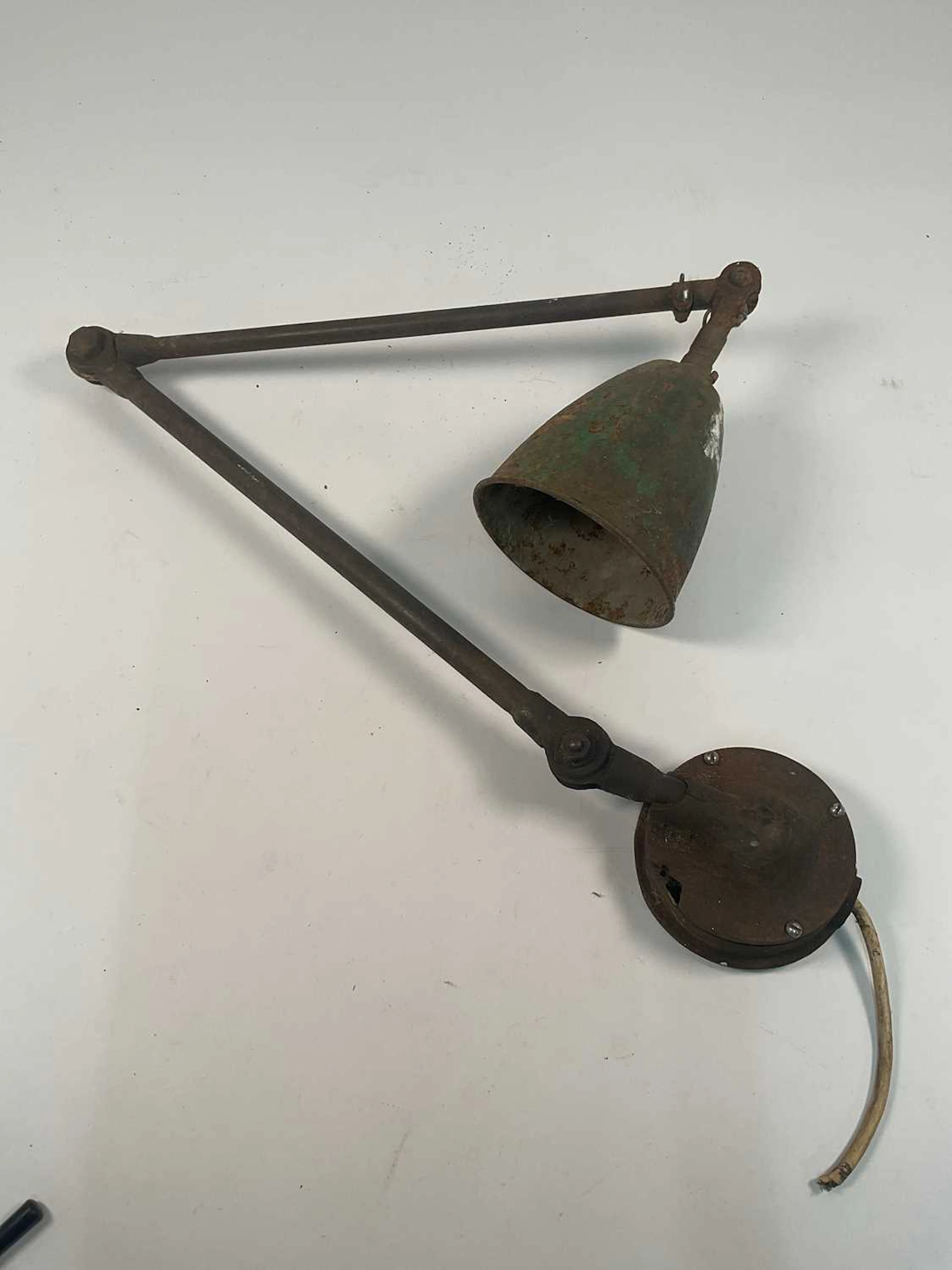 A vintage industrial machinist's articulated work lamp with green enamel shade