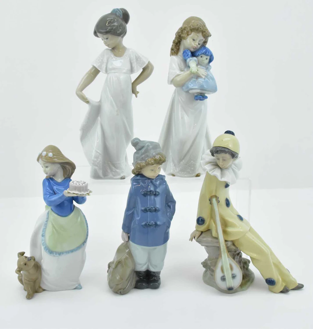 NAO; five high gloss Spanish porcelain figures comprising harlequin with lute