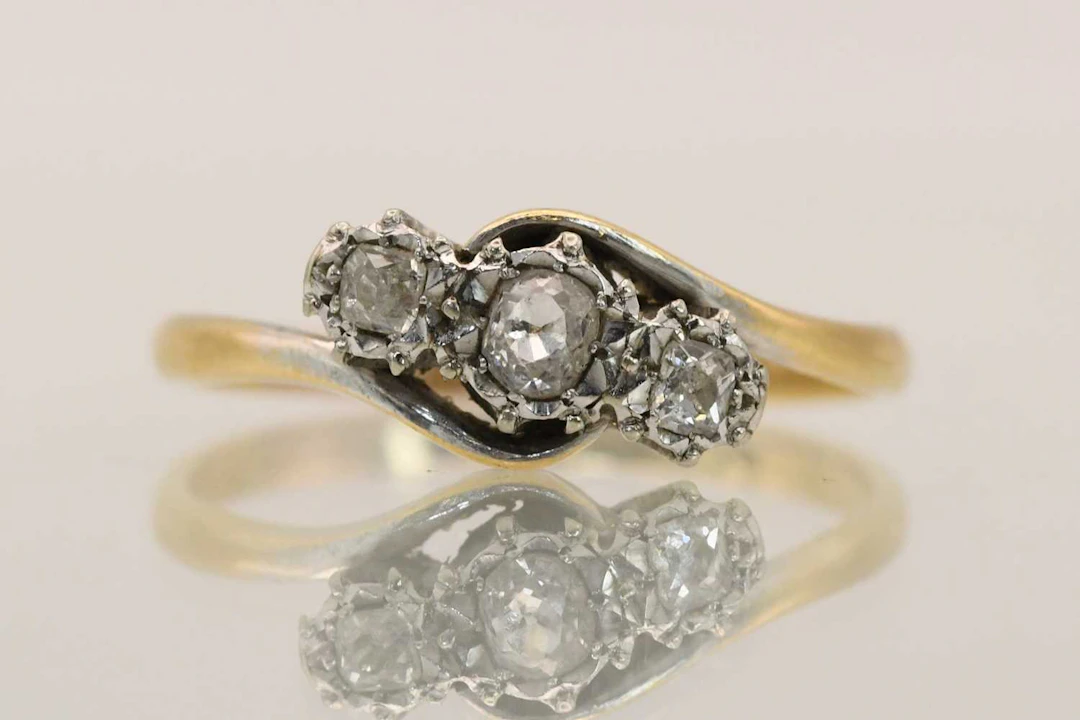 An 18ct yellow gold three stone diamond set crossover ring