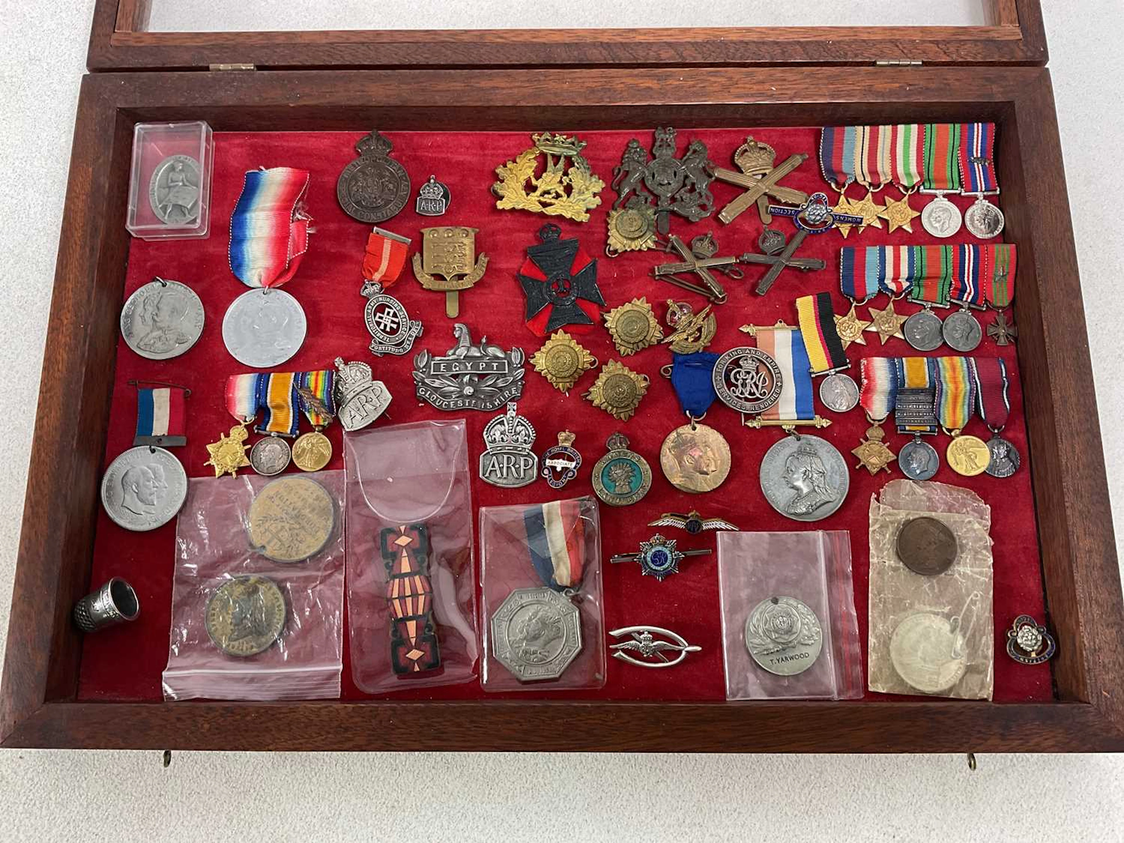 A collectors' table top cabinet containing a quantity of military collectables