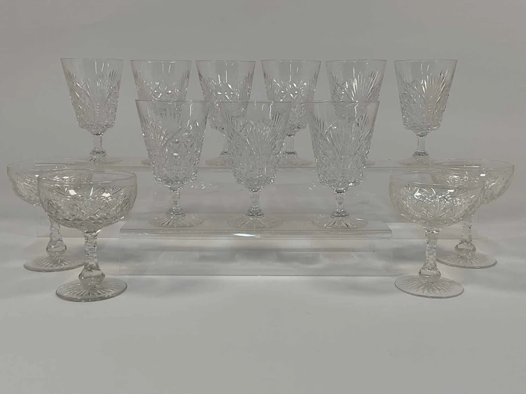 A quantity of cut crystal champagne coupes and wine glasses