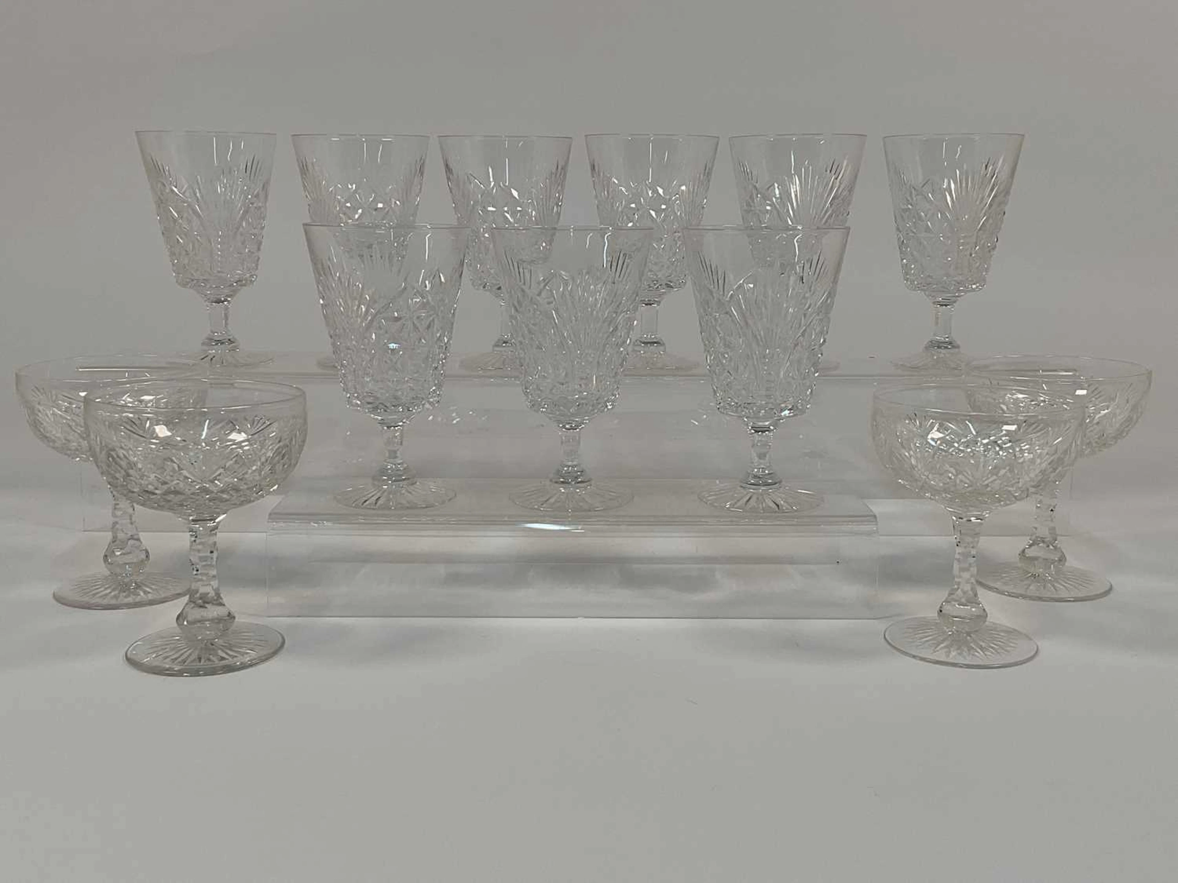 A quantity of cut crystal champagne coupes and wine glasses