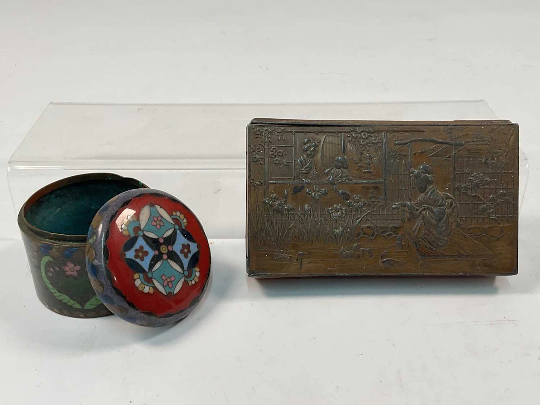 A Japanese embossed metal box decorated with a relief...