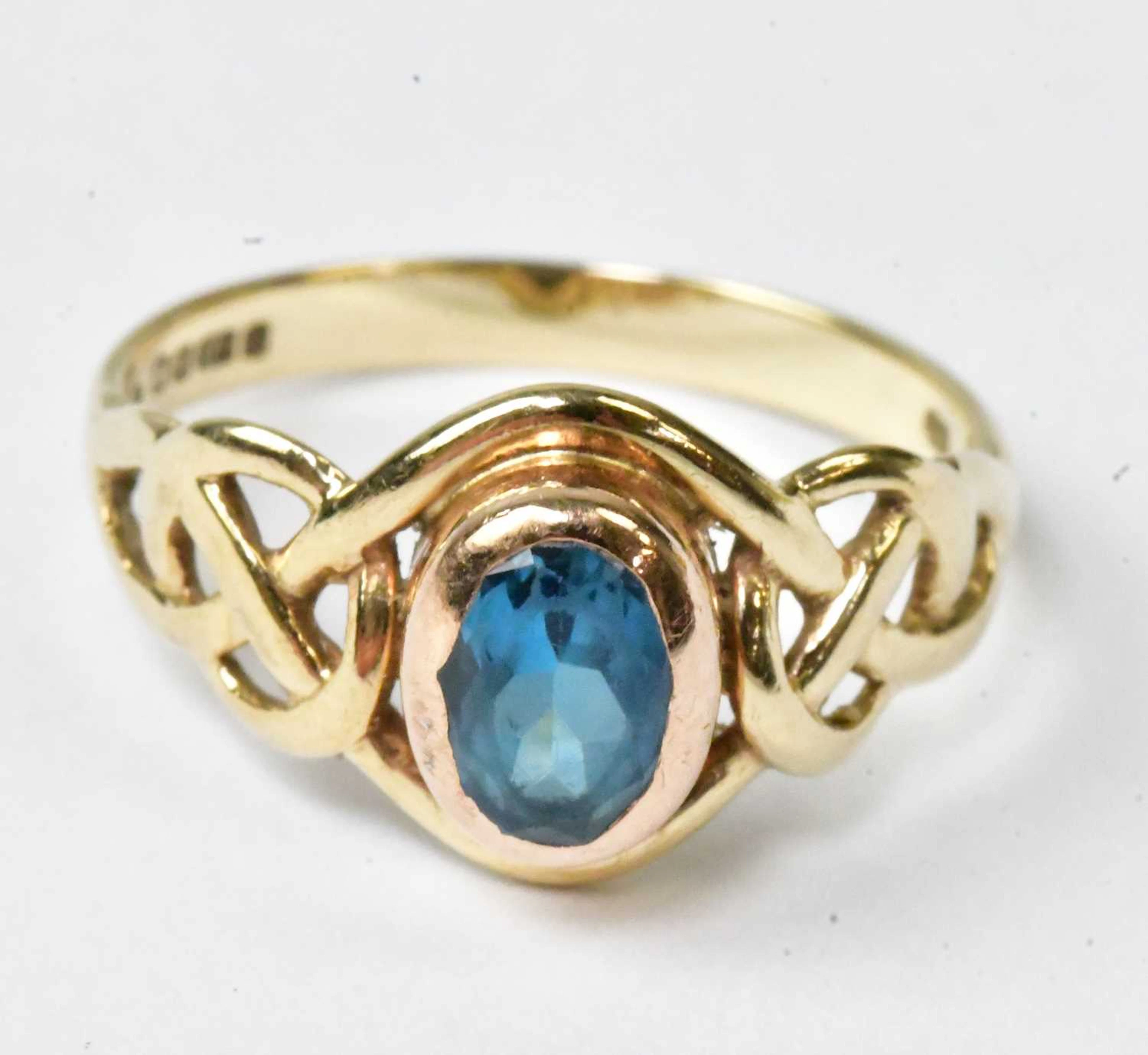 A 9ct yellow gold ring set with a central oval blue stone