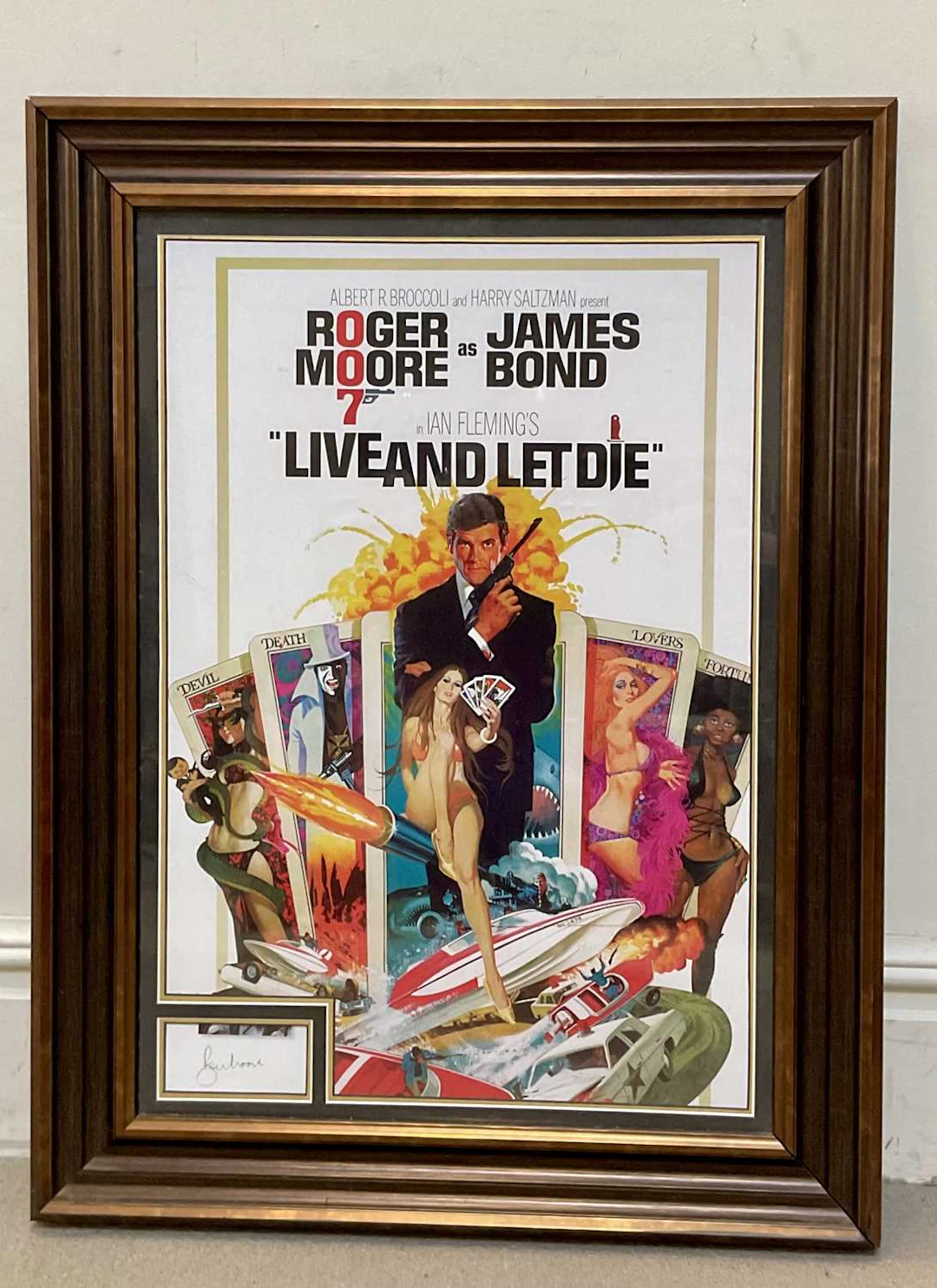 ROGER MOORE; an autographed reproduction poster for Live and Let Die